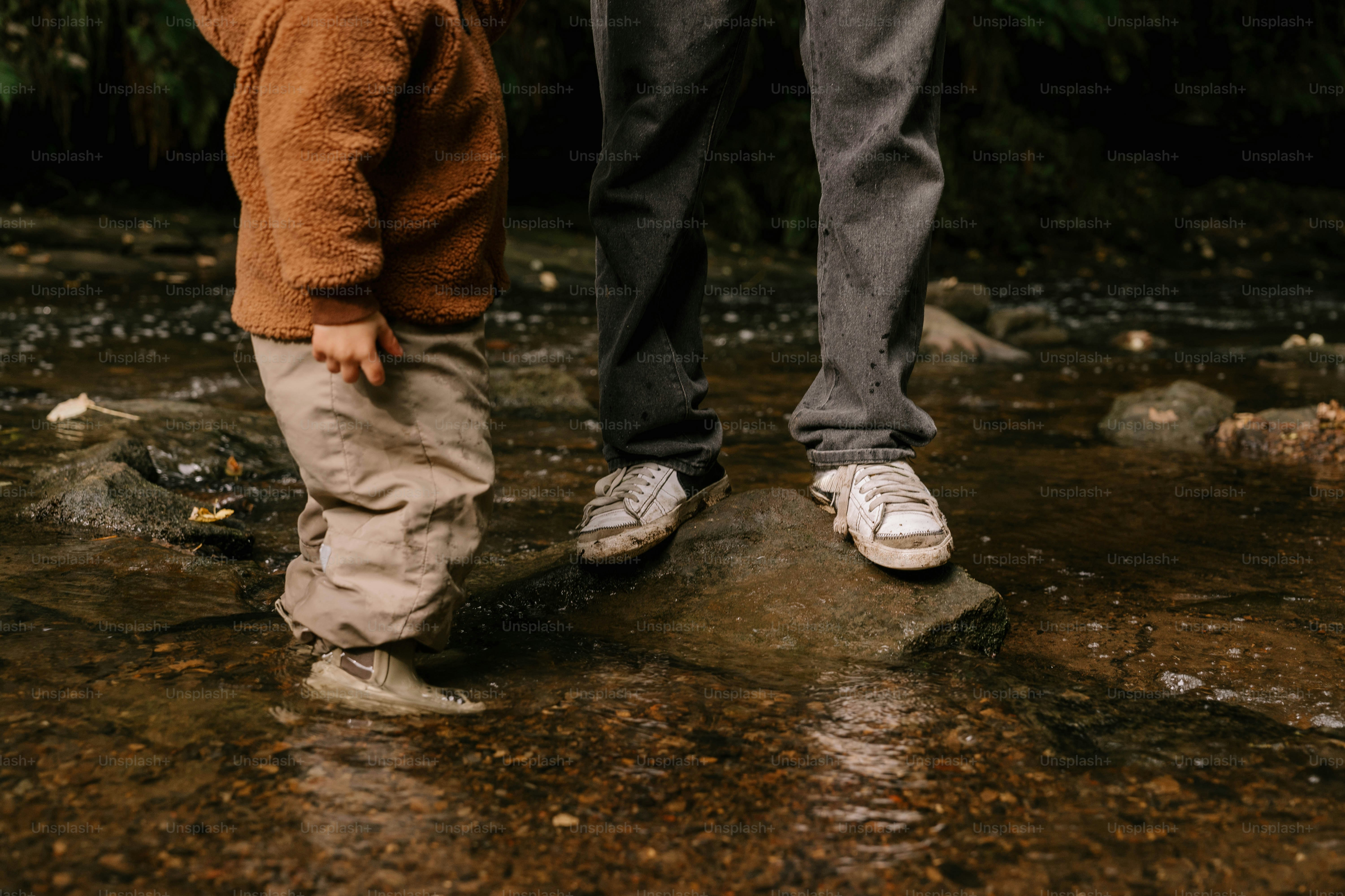 A man and a child standing in a stream