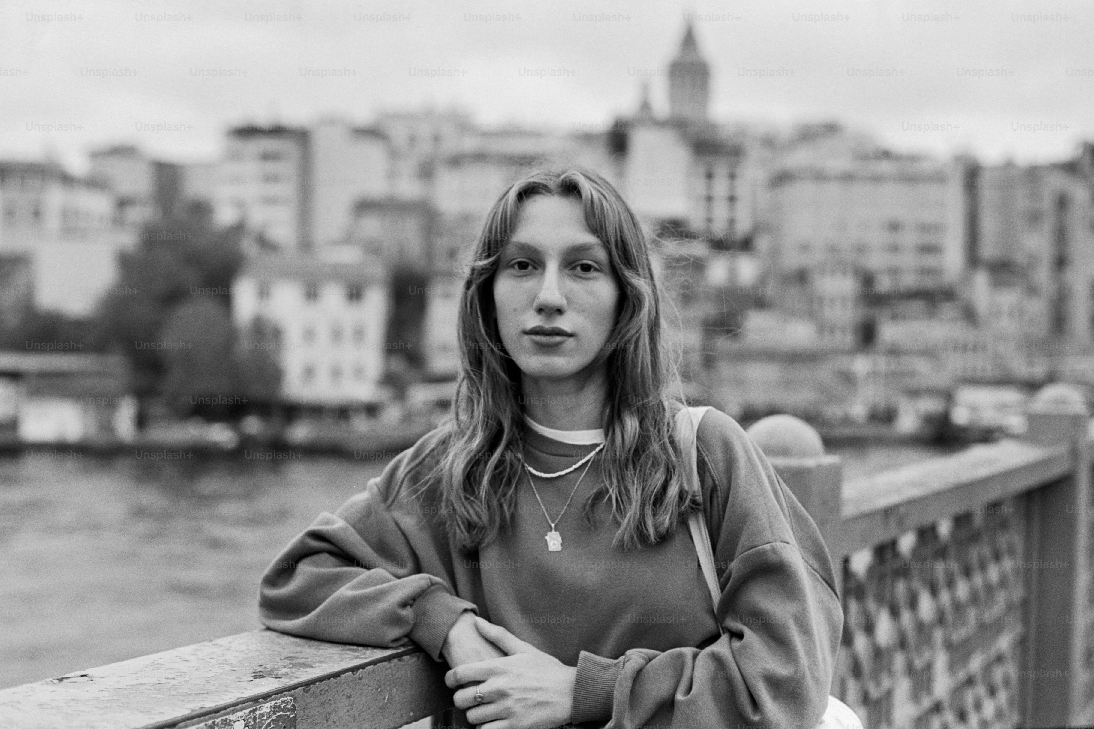 A woman standing on a bridge next to a body of water