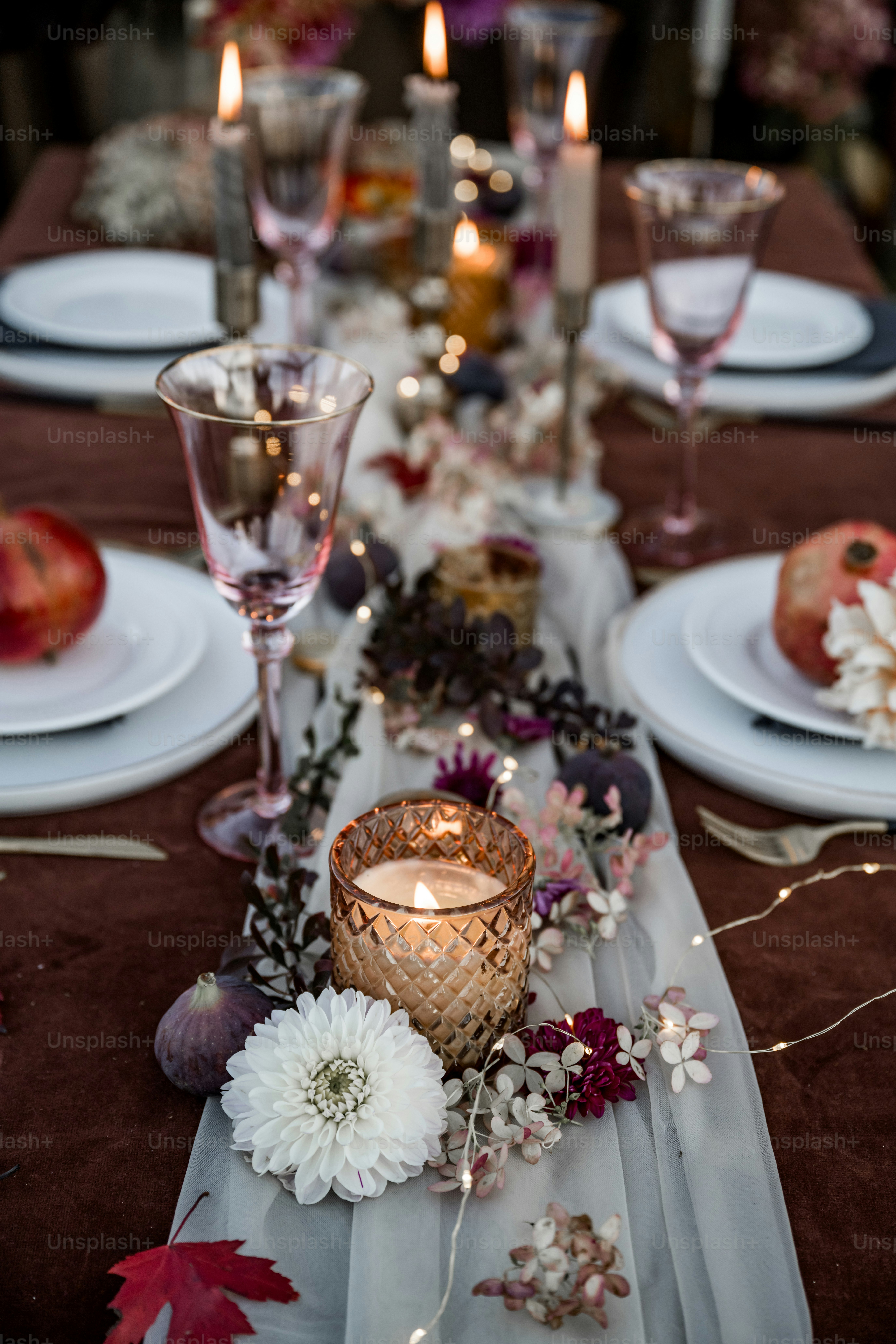 A table set with plates, candles and flowers