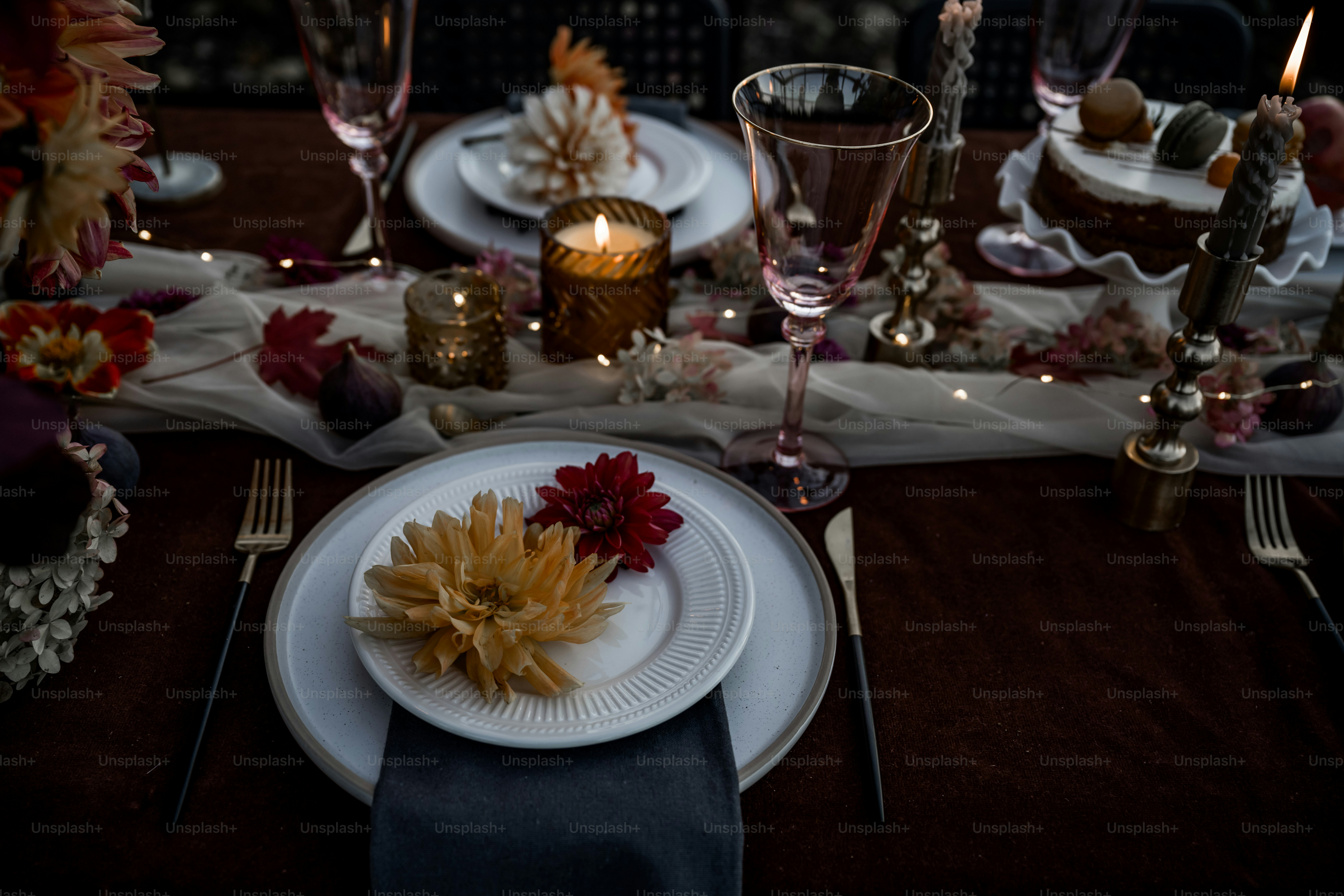 A table set with plates, silverware and candles