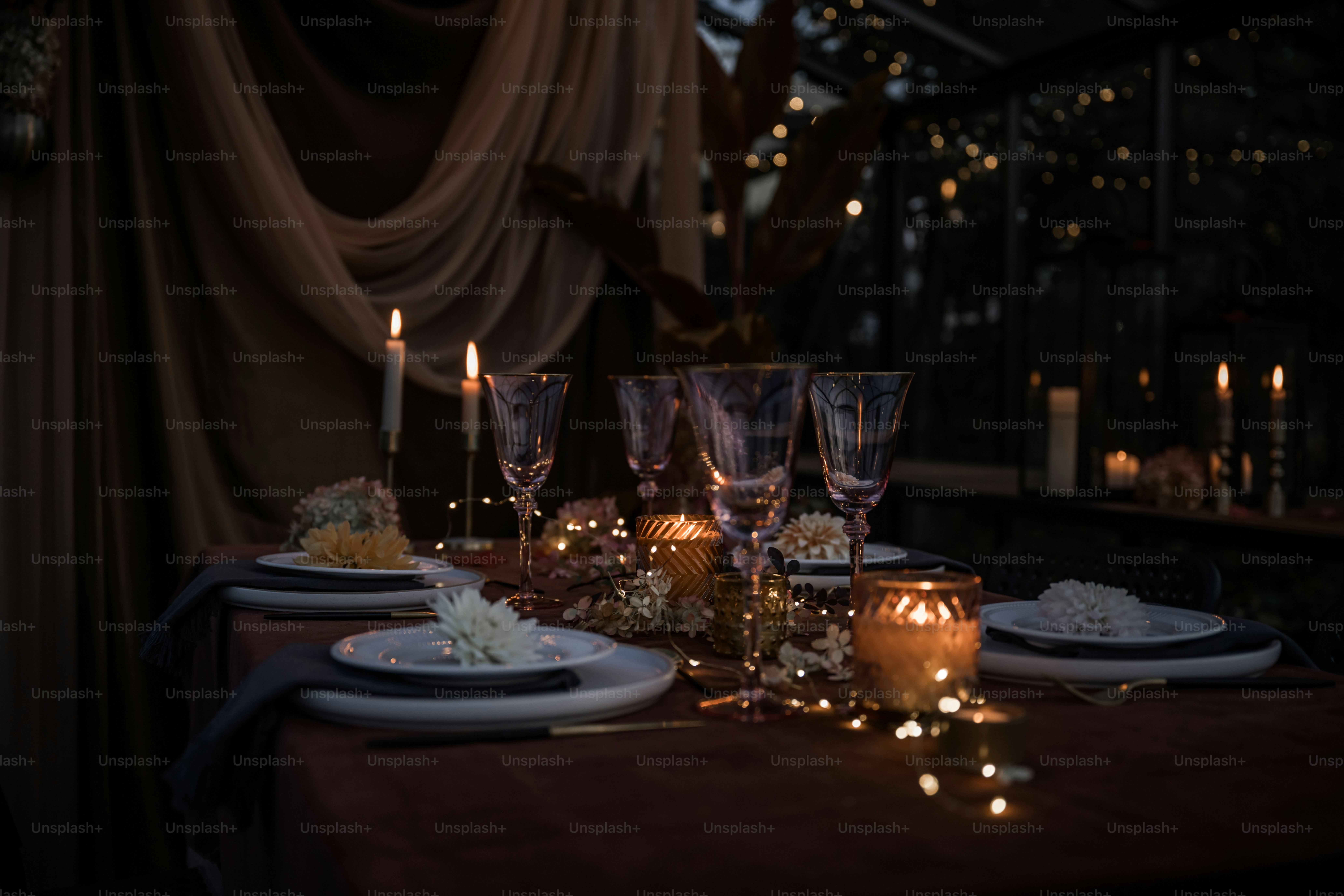A dinner table with candles and plates on it