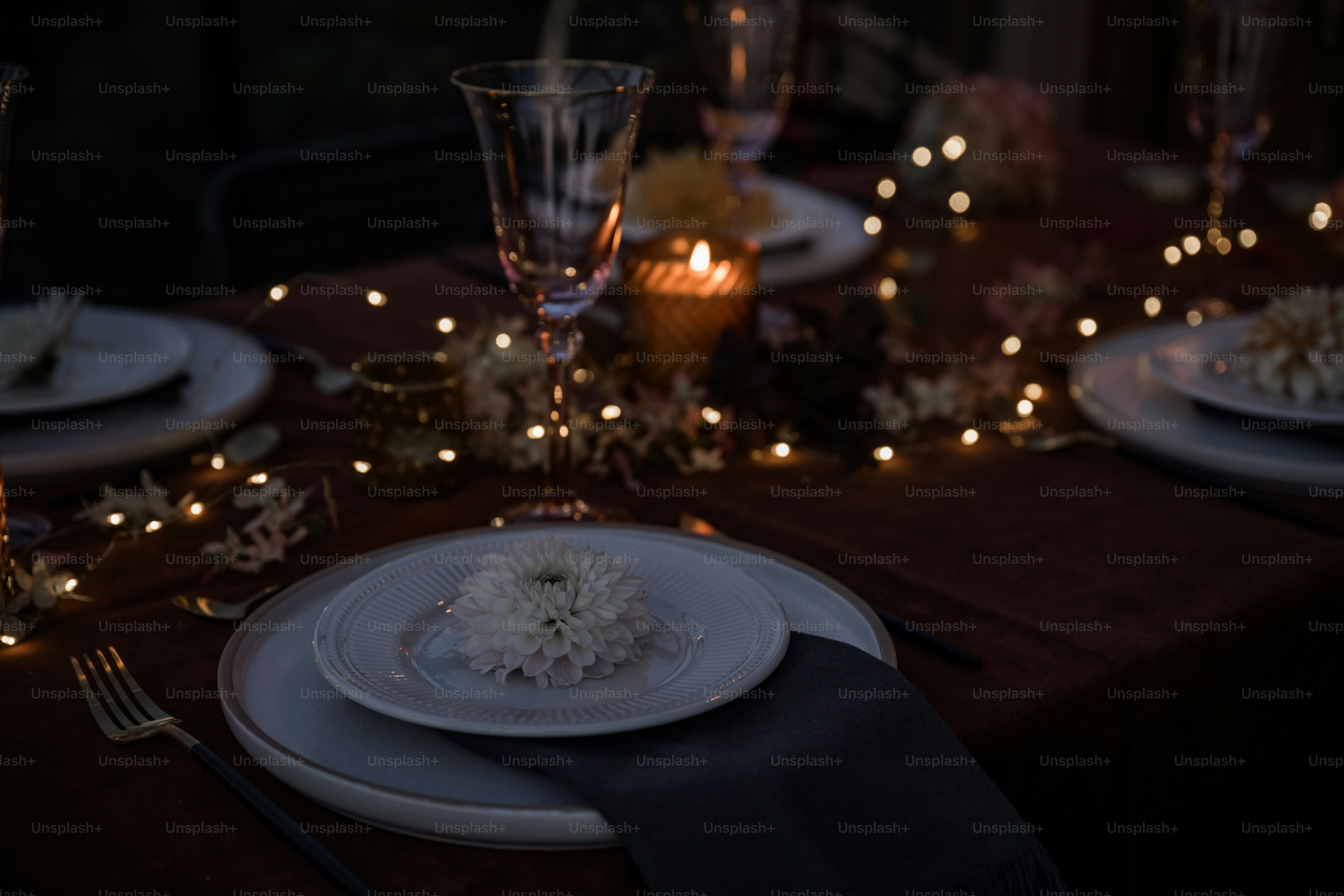 A table set with plates, silverware and candles