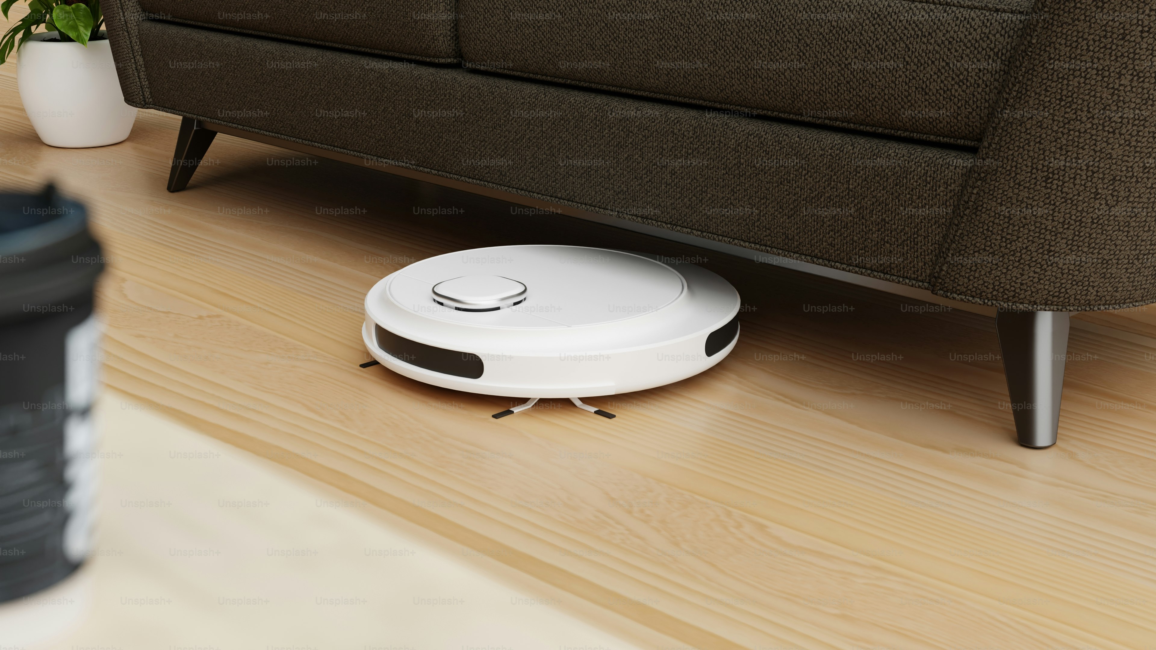 A living room with a couch and a robot vacuum on the floor