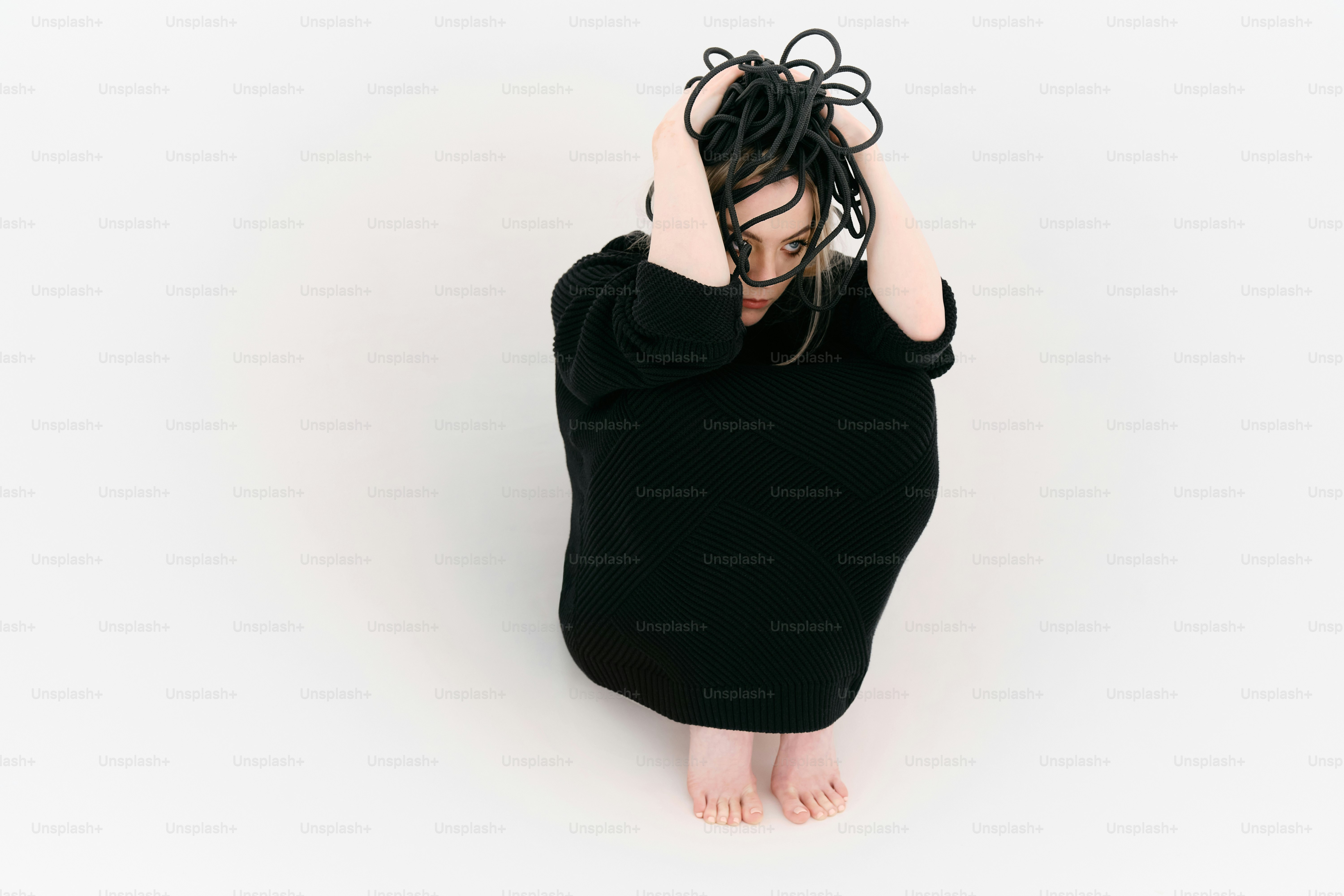 A woman sitting on the floor with her hands in her hair photo – Sad ...