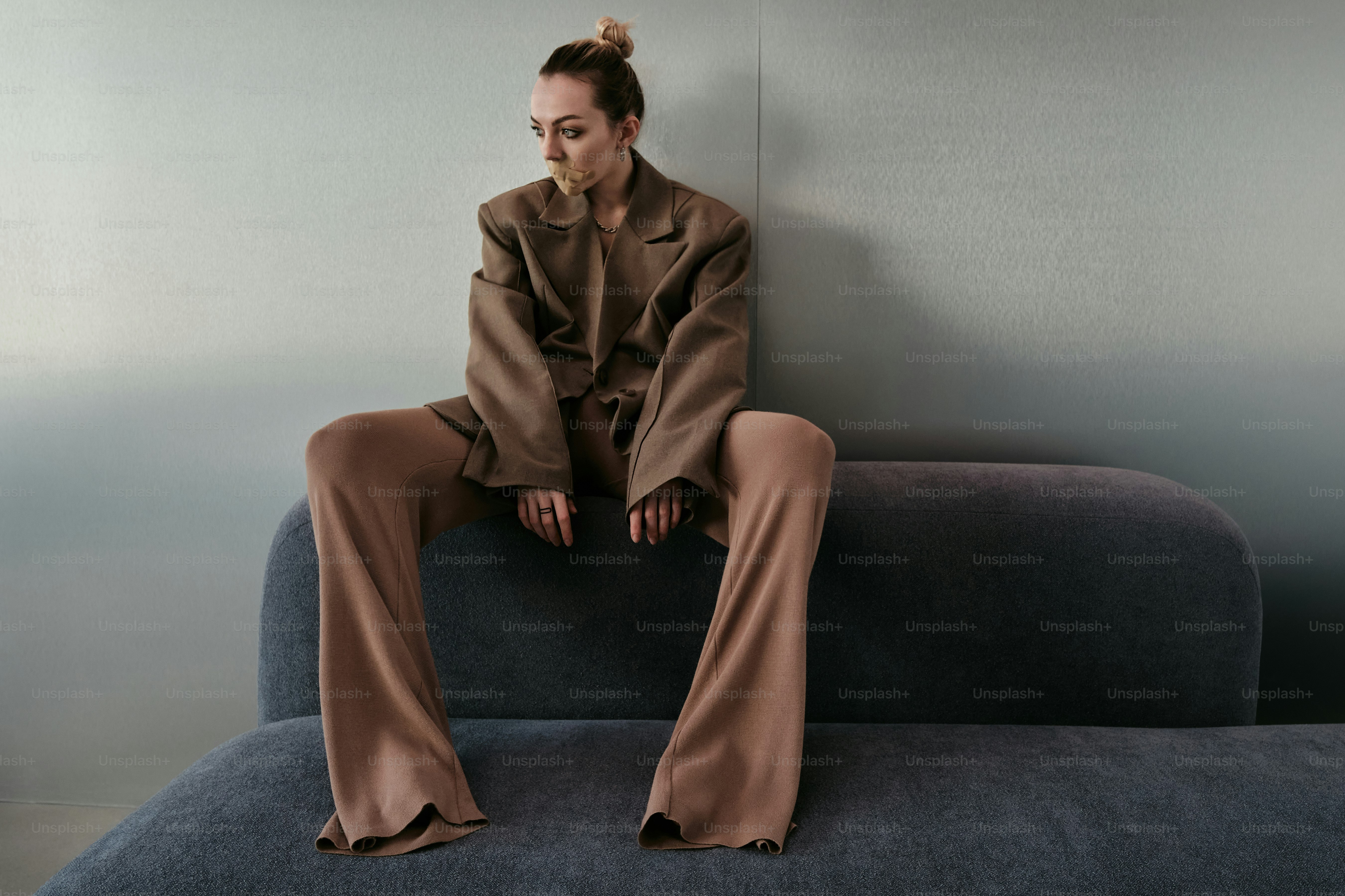 A woman sitting on top of a blue couch