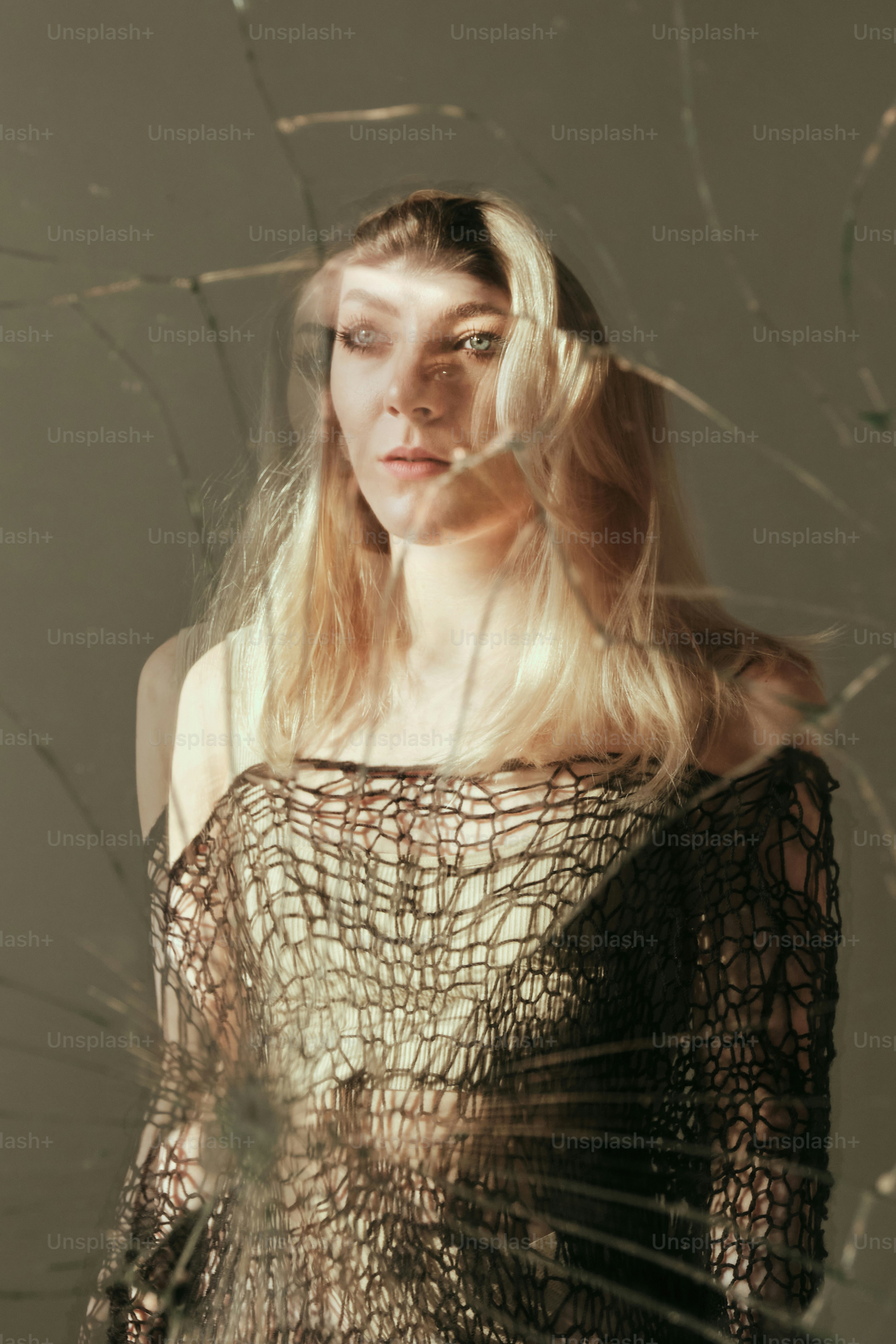 A woman standing in front of a broken glass window