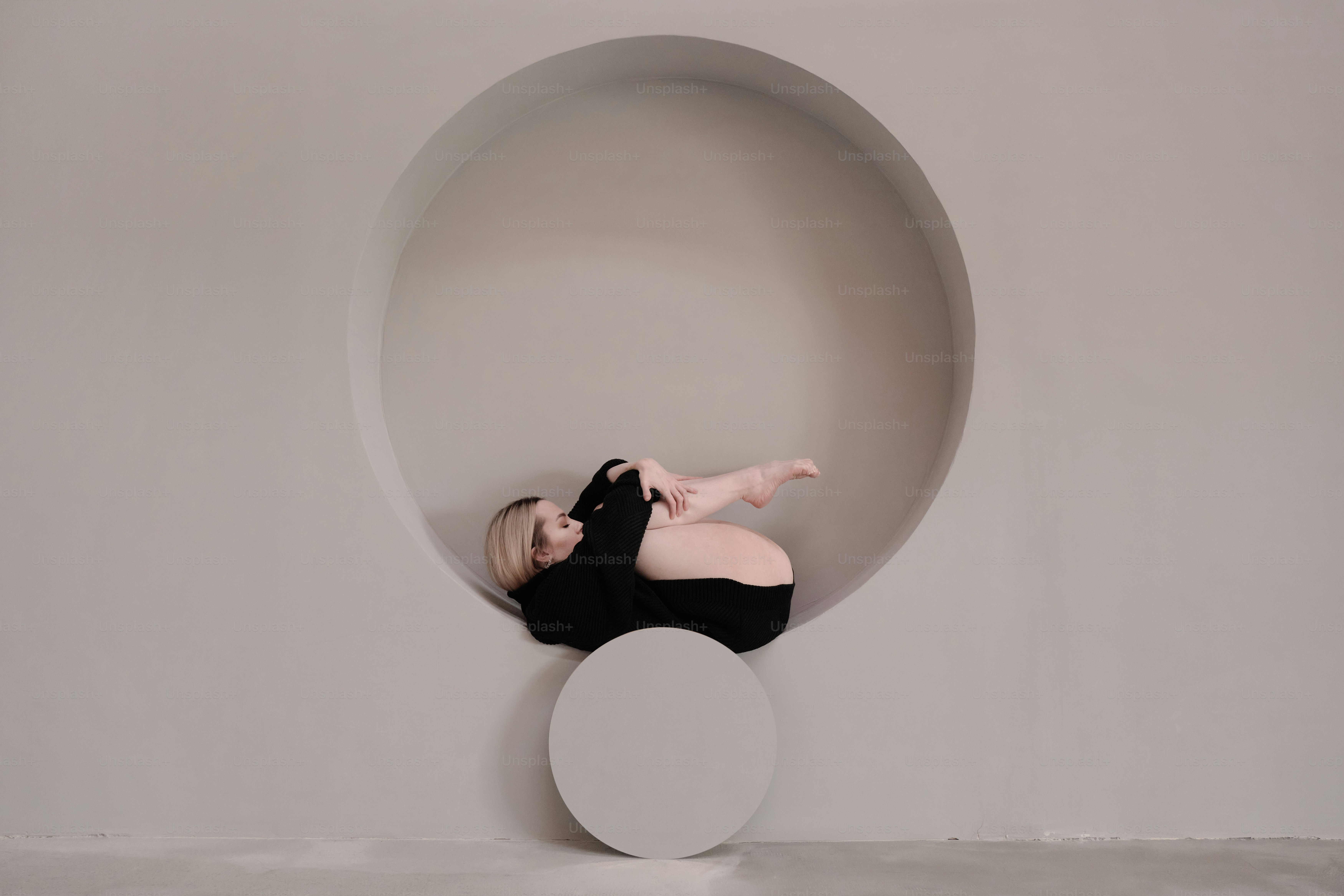 A woman in a black dress laying on a white object