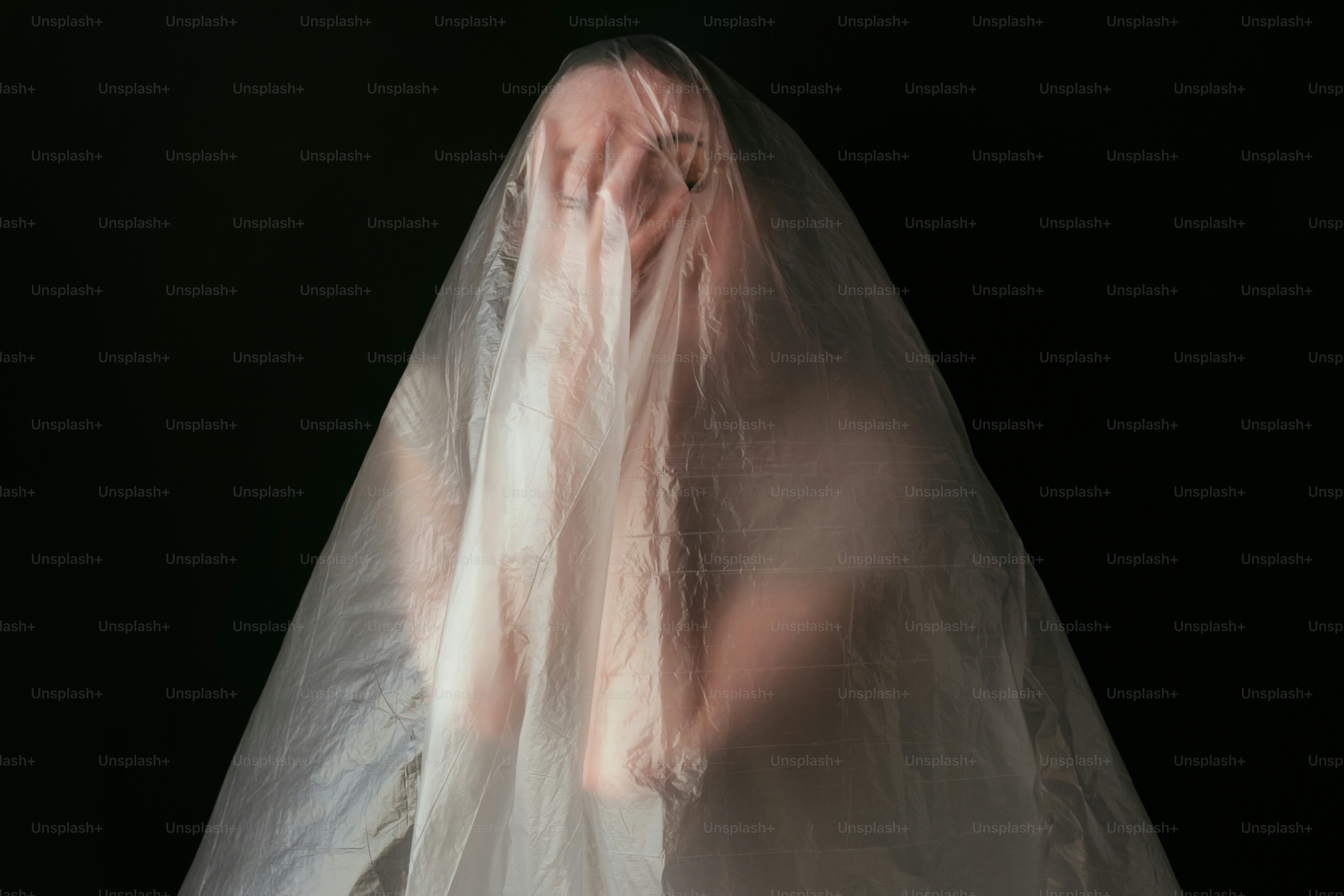 A woman in a white veil is standing in the dark