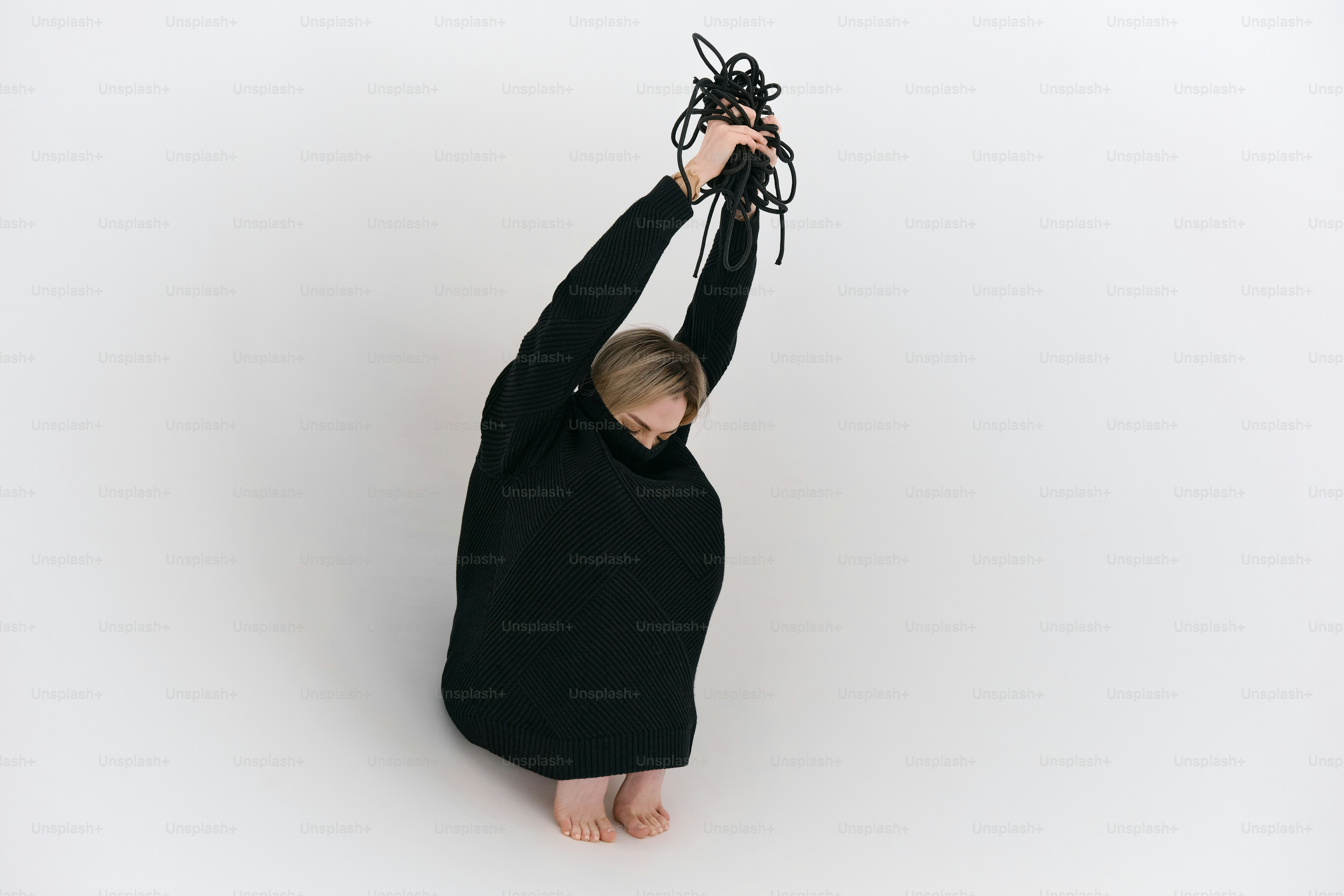 A young boy in a black shirt holding a black object in the air