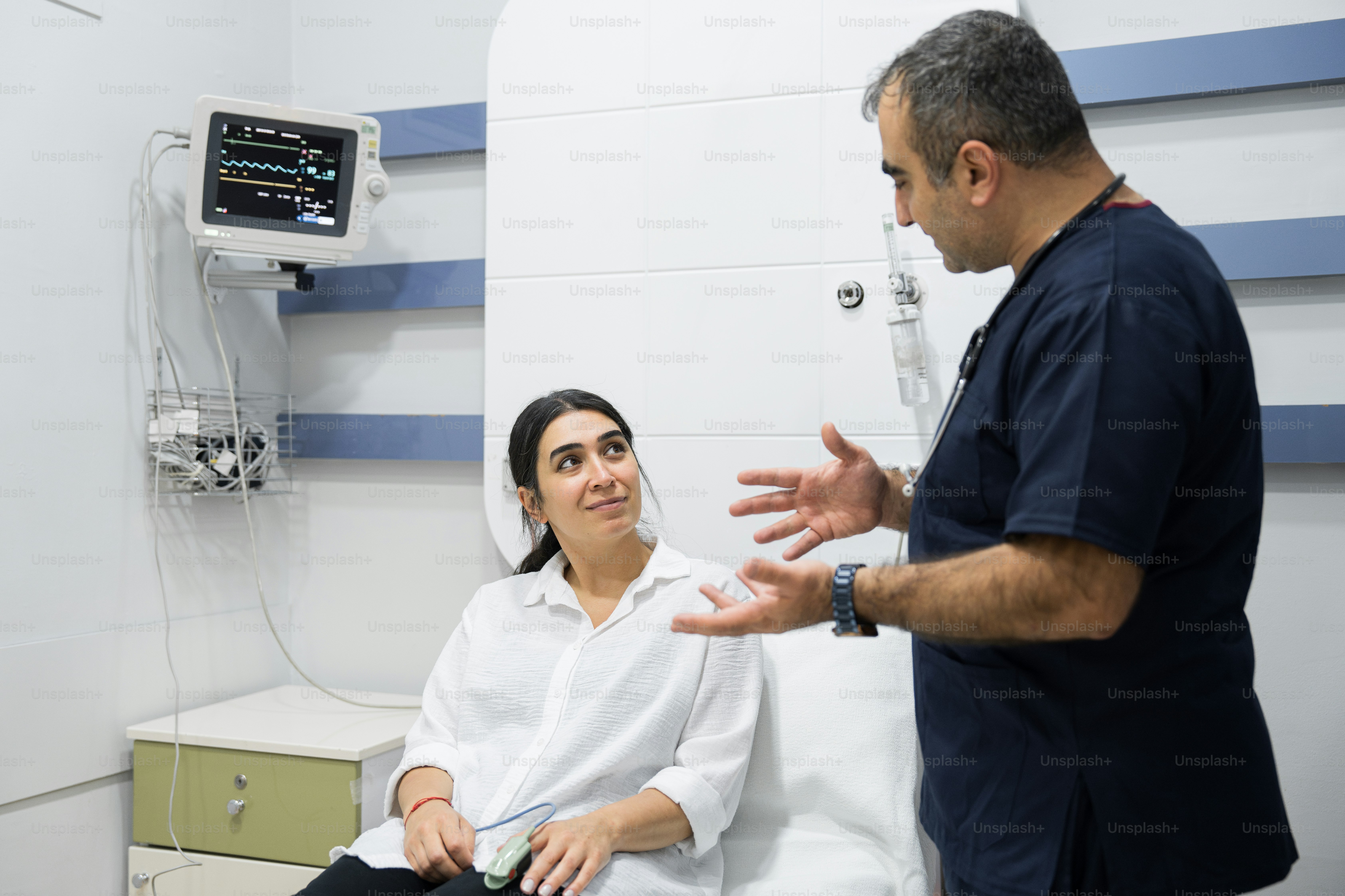 Un homme discutant avec une femme dans une chambre d’hôpital