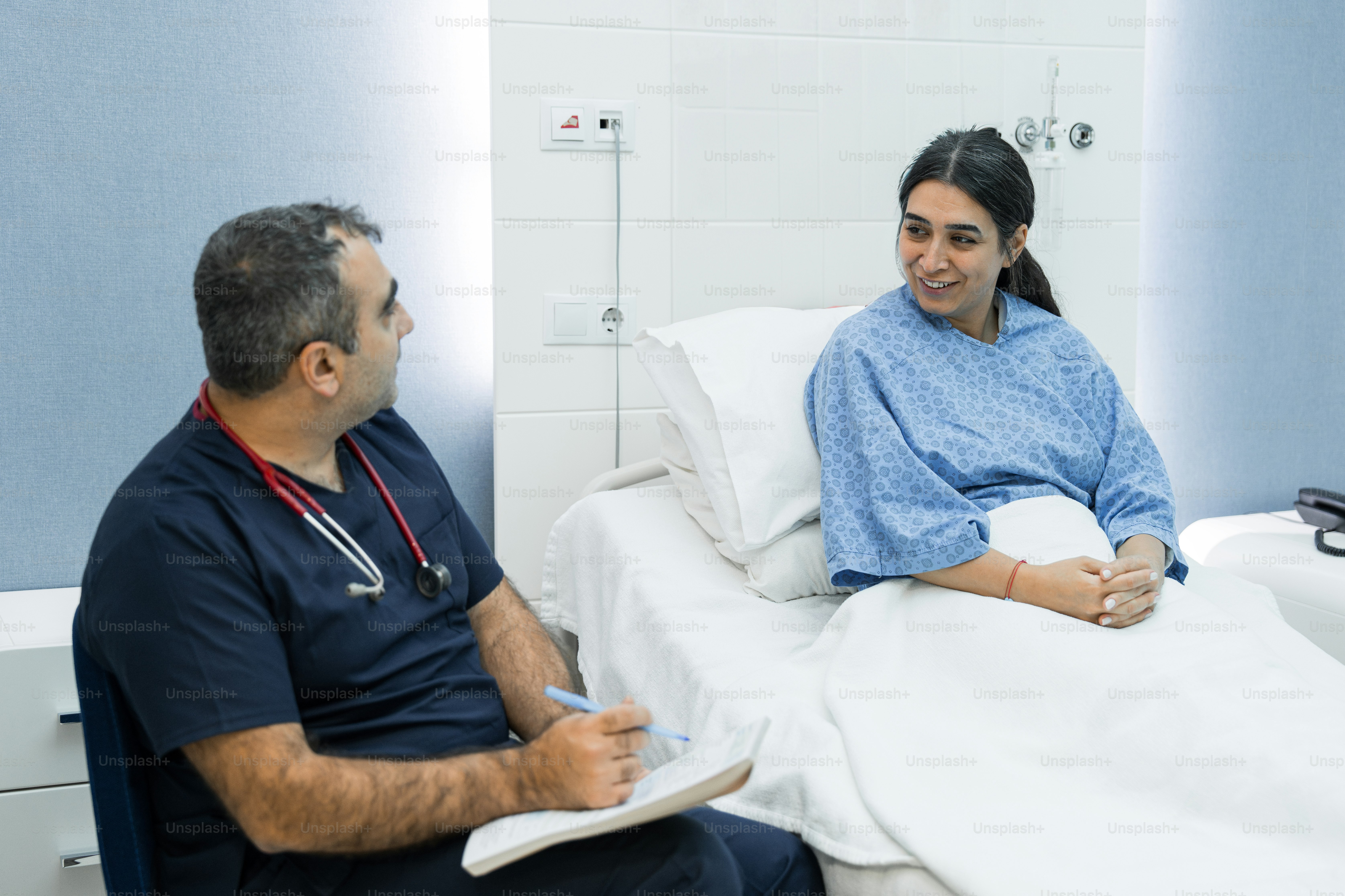 A man and a woman sitting in a hospital bed