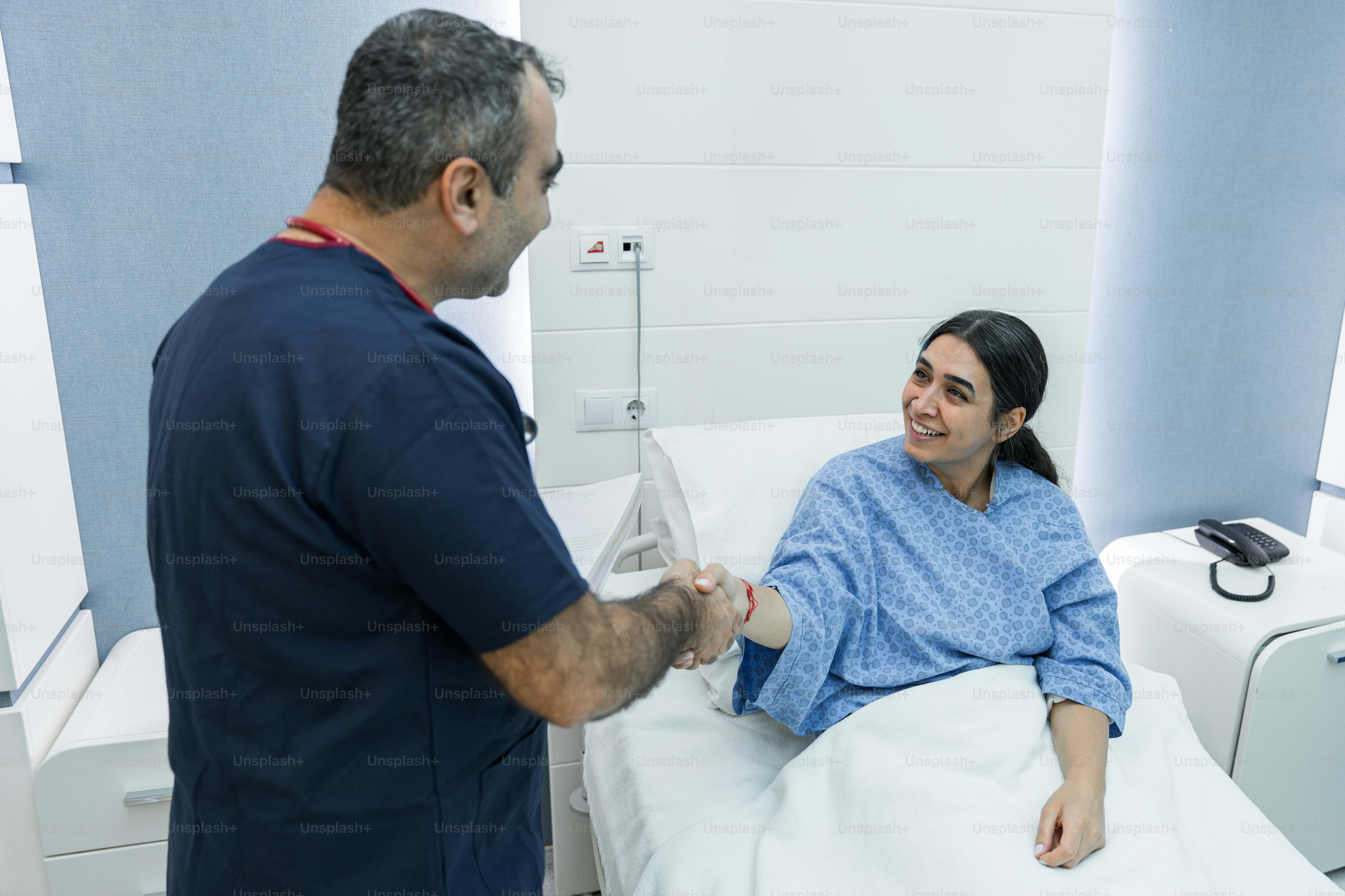A man standing next to a woman in a hospital bed