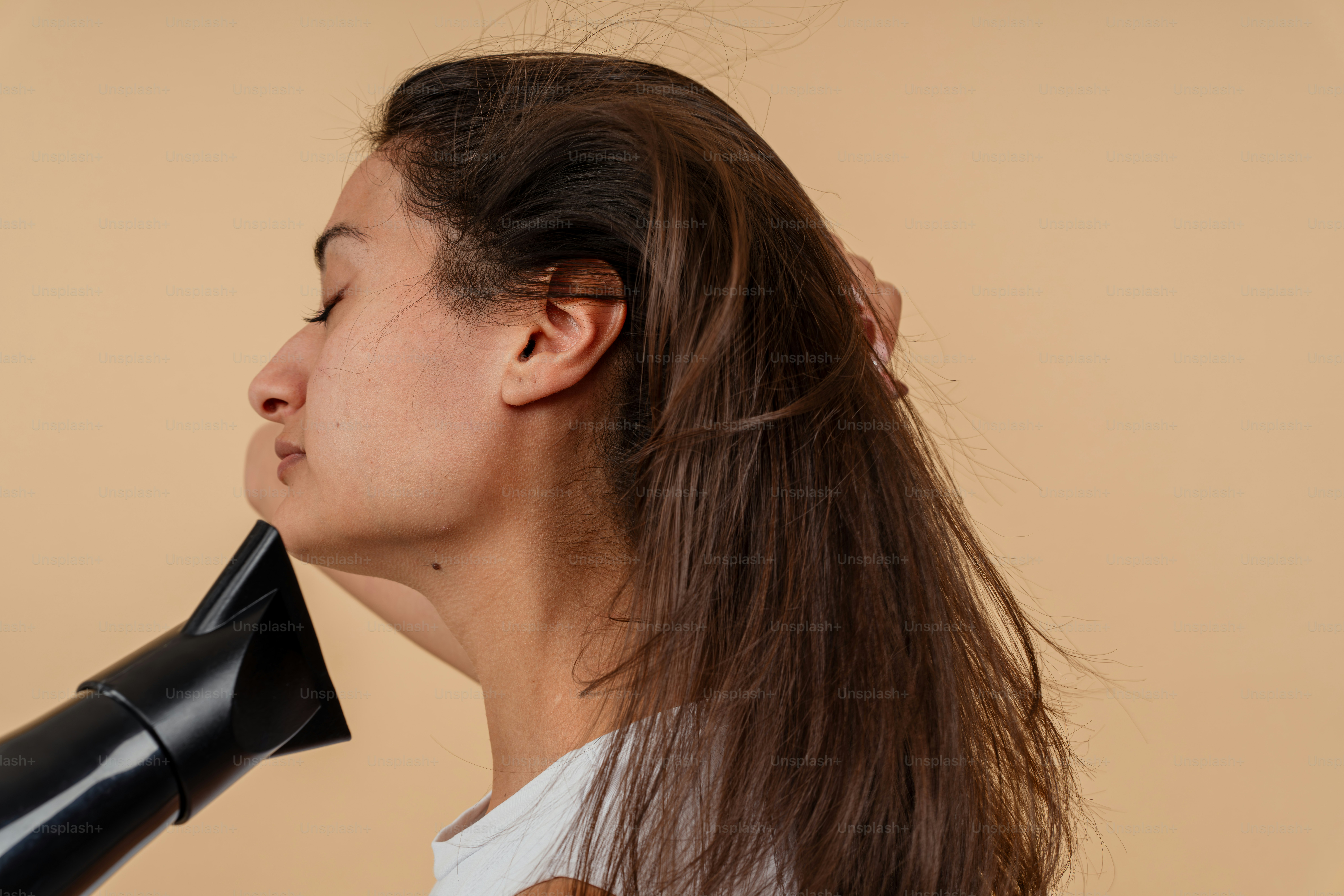 Eine Frau, die sich die Haare mit einem Fön föhnt