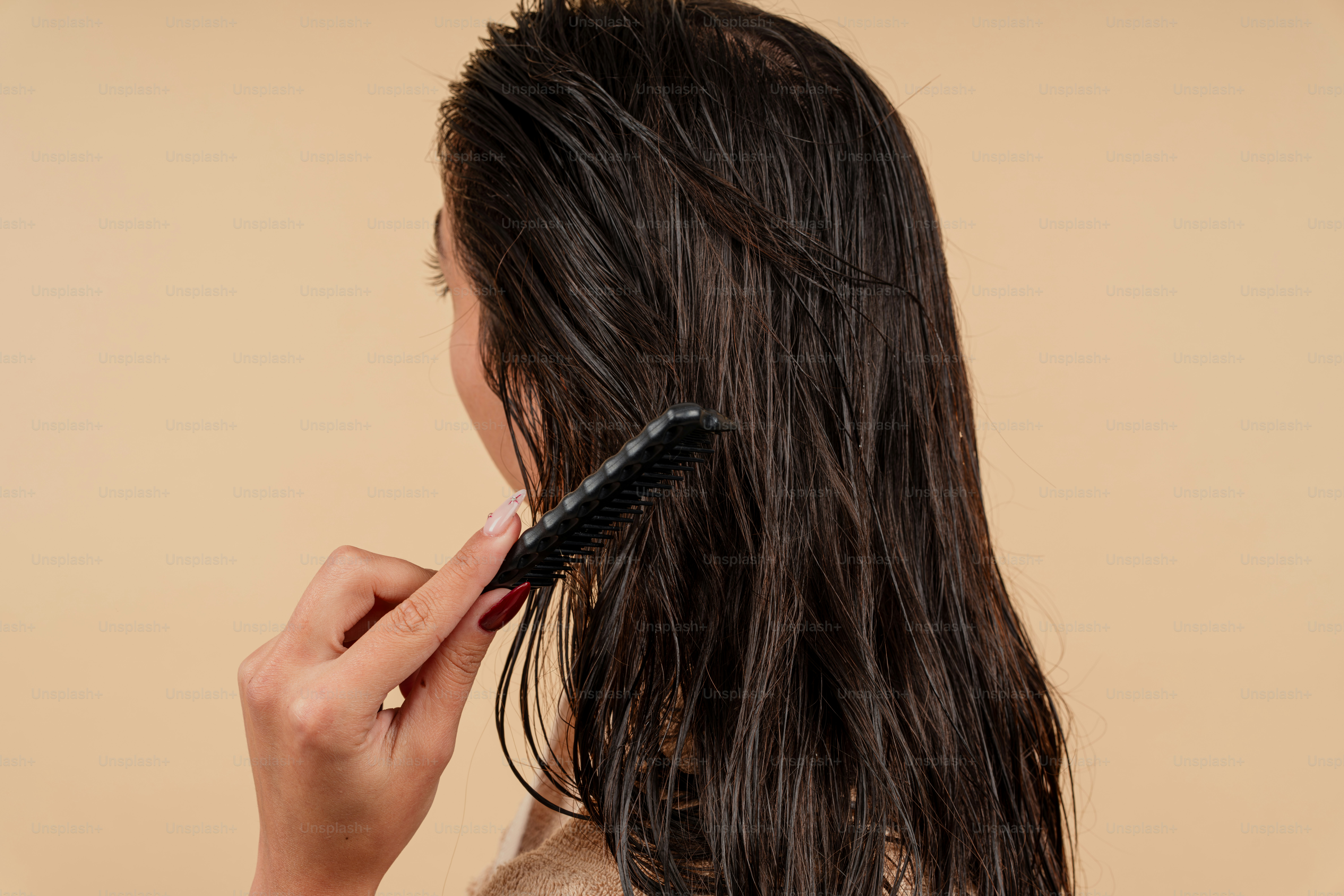 A woman brushing her long hair with a brush