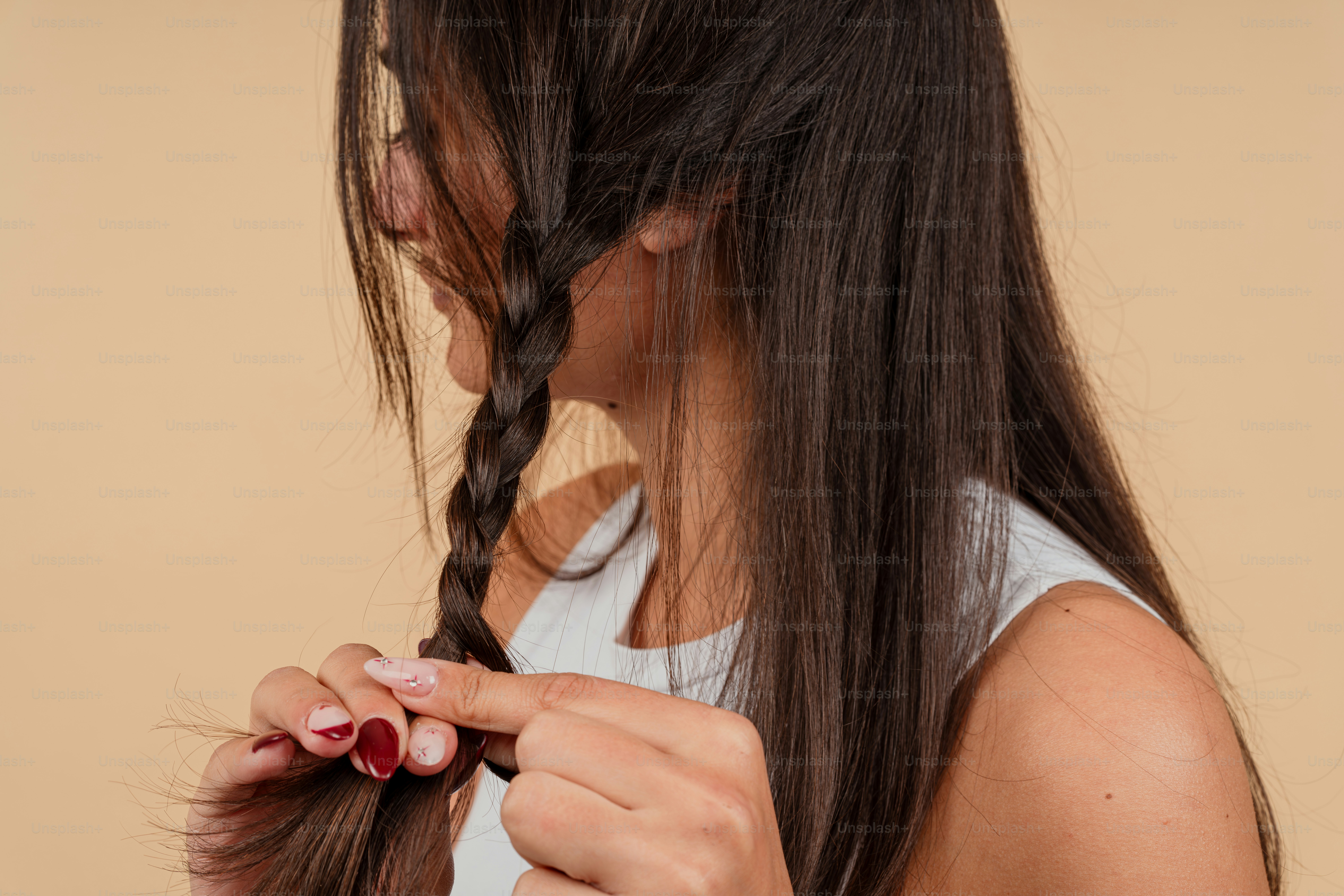 A woman is braiding her hair with a pair of scissors