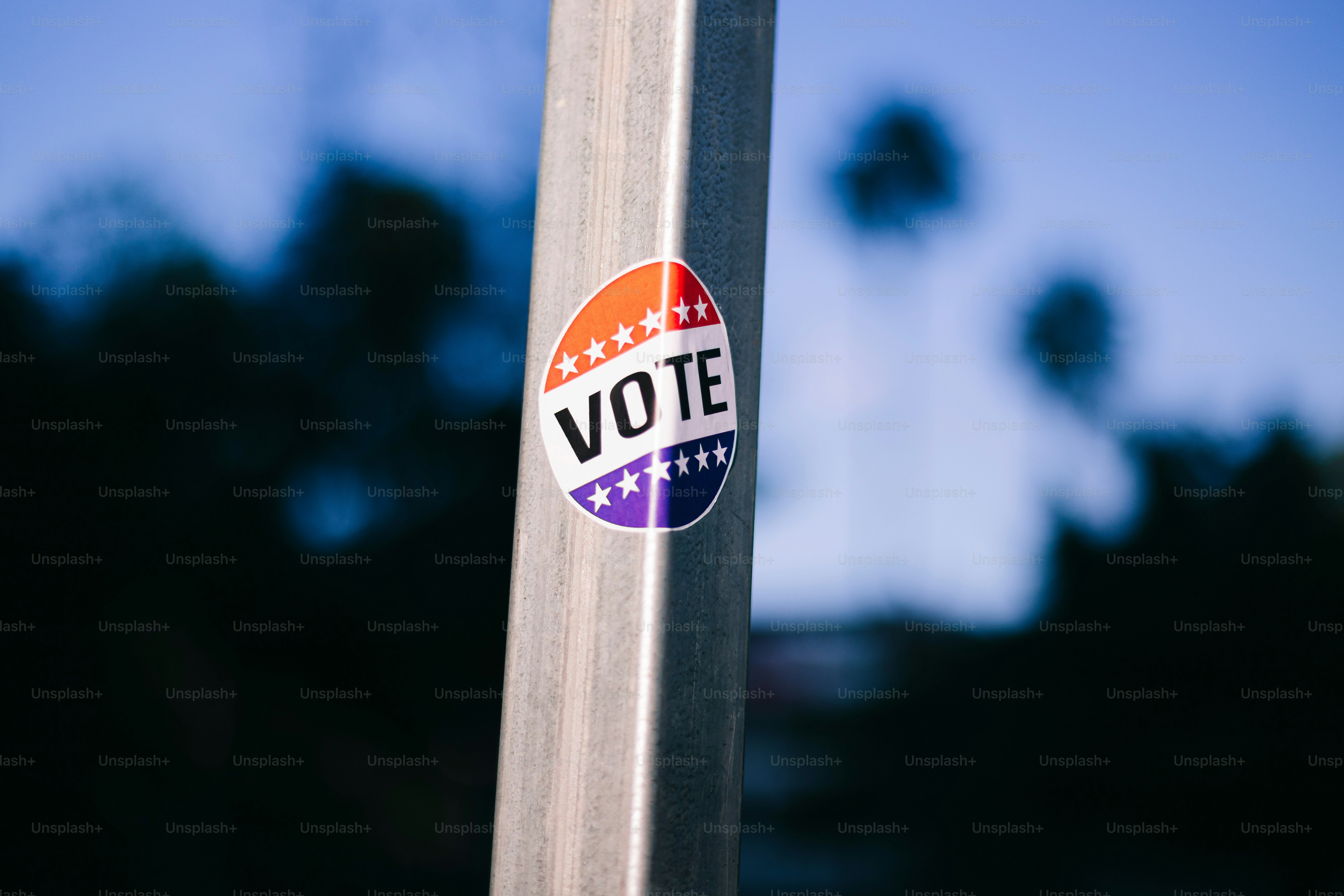 A sticker on a pole that says vote