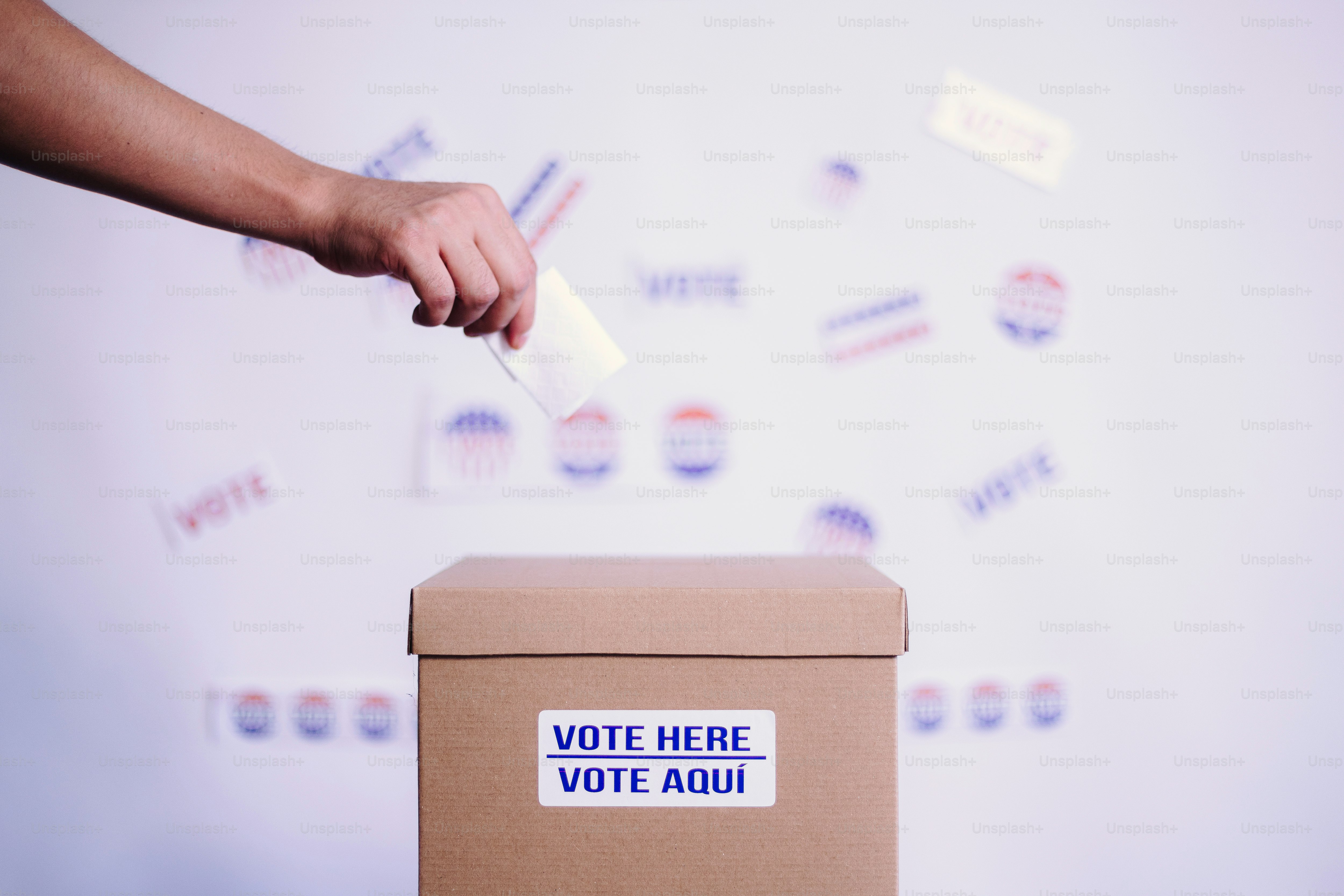 A person putting a voting sticker on a voting box