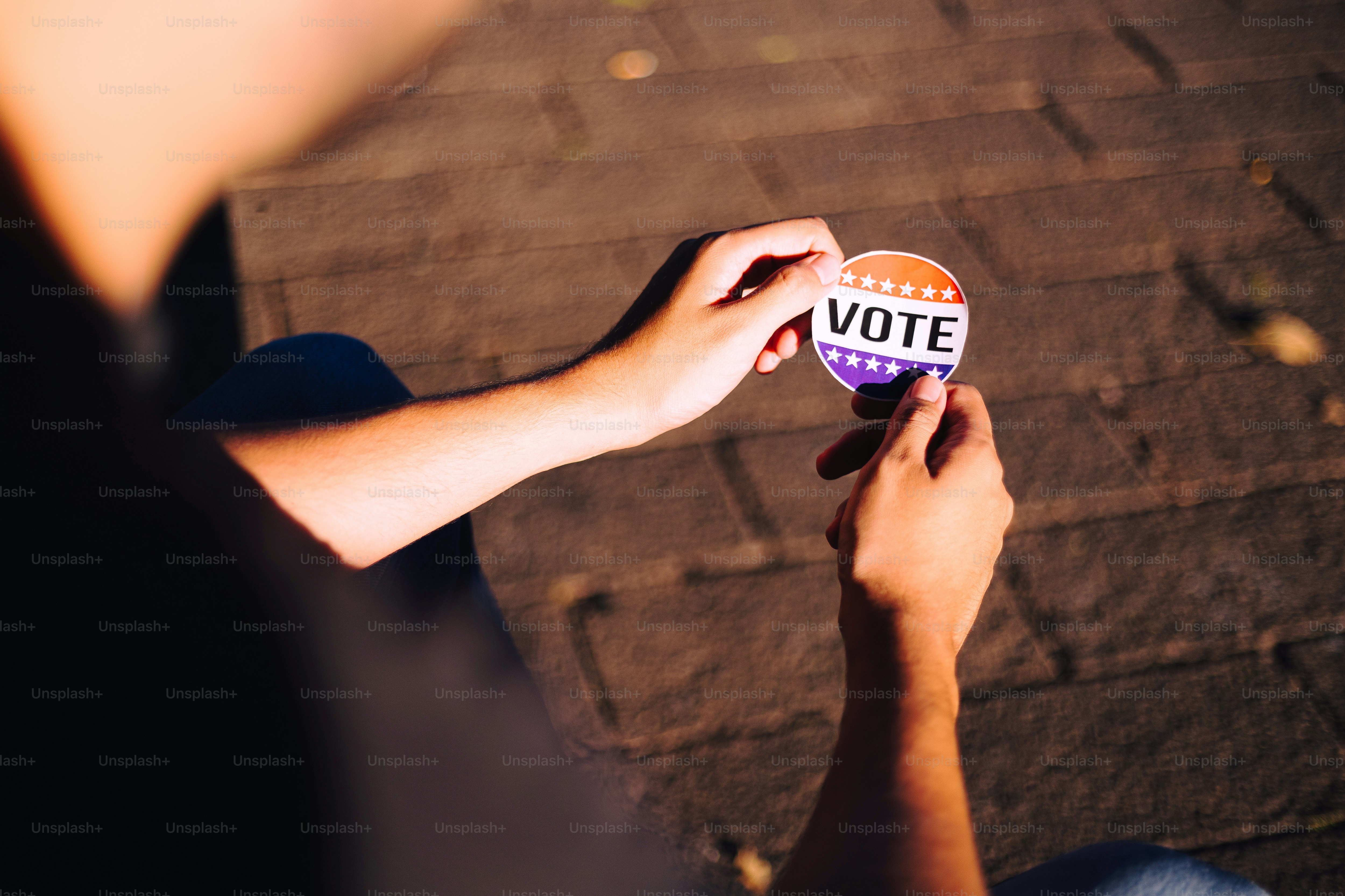 A person holding a vote sign in their hand