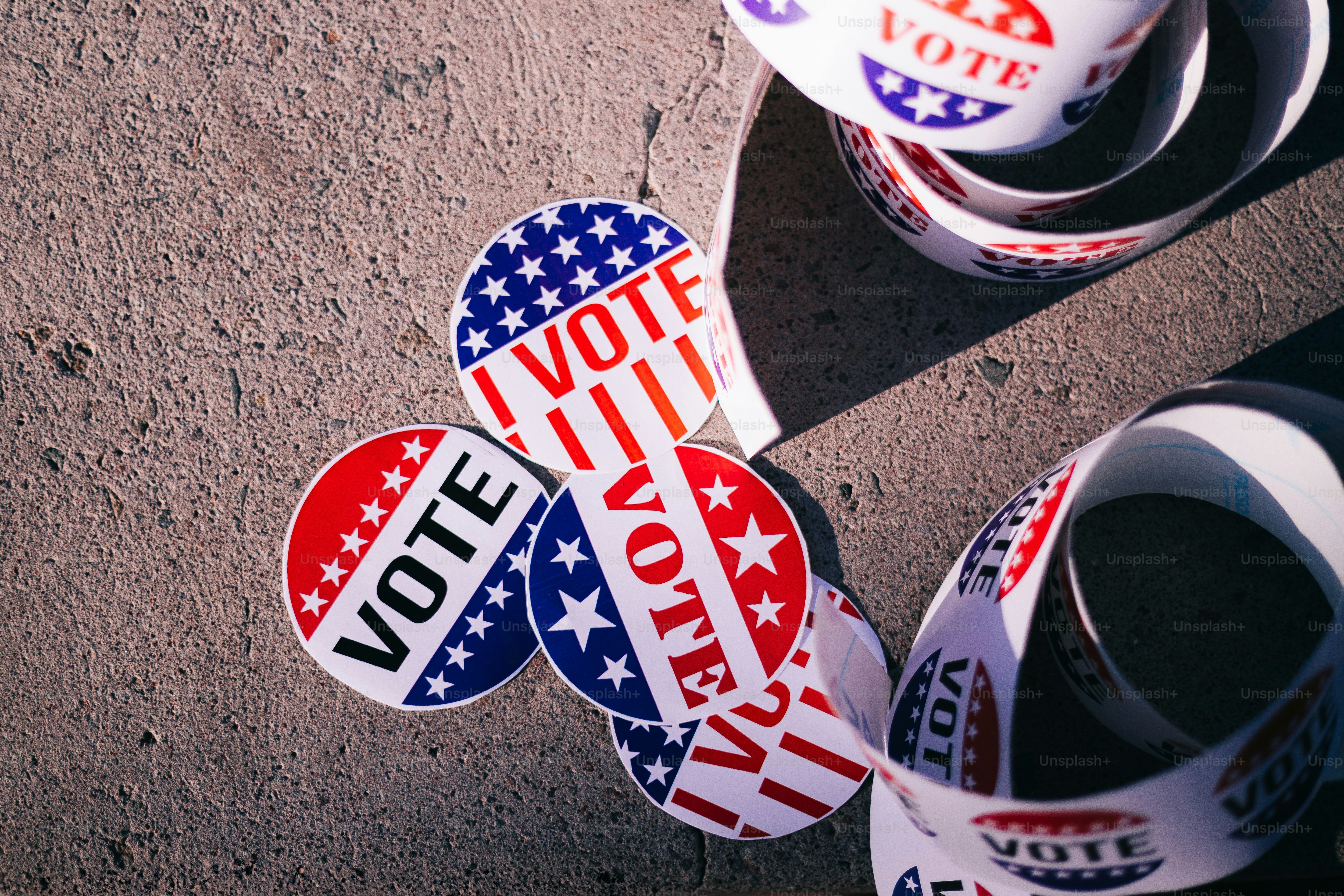 A group of political stickers sitting on top of a sidewalk