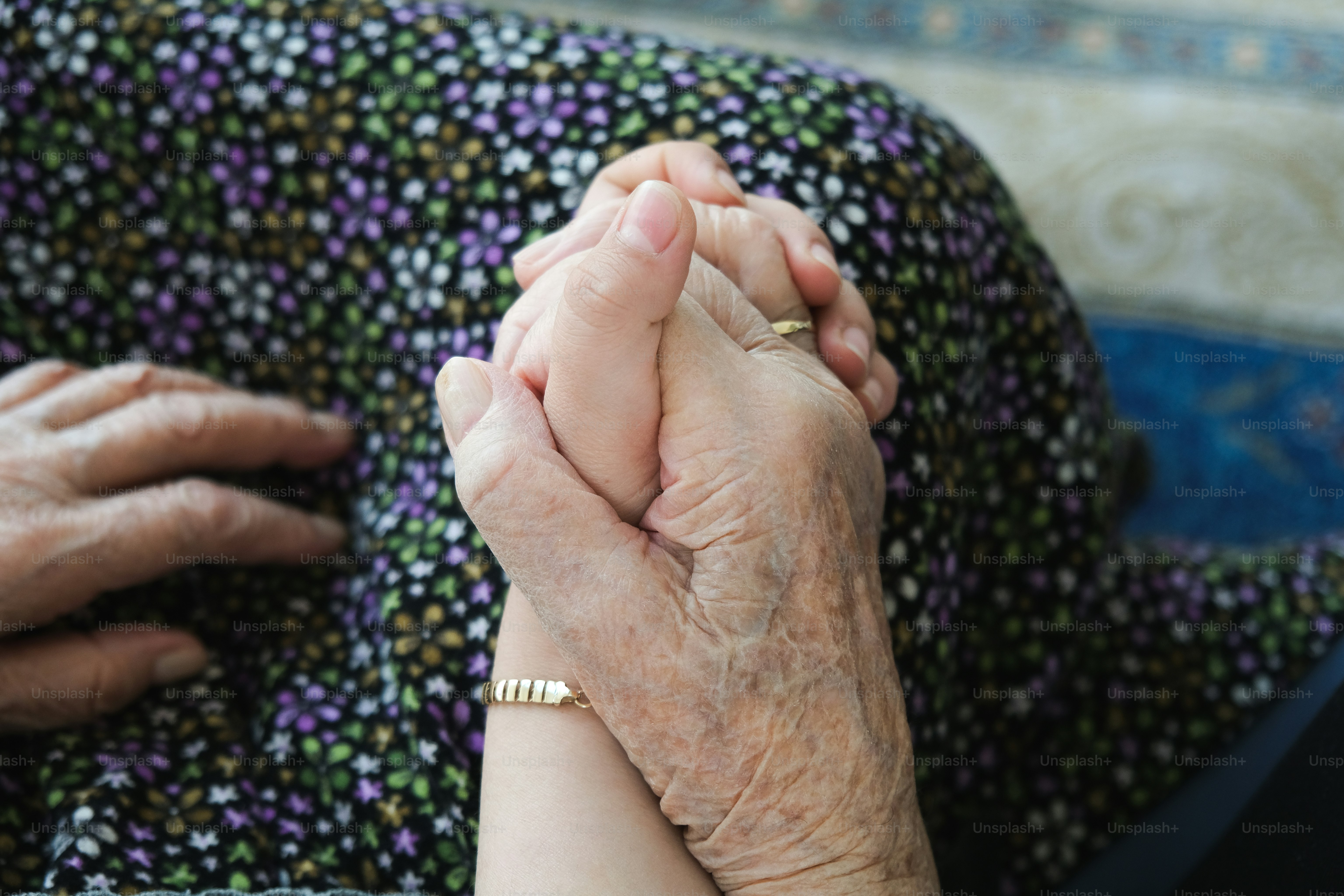An older woman holding a younger woman's hand