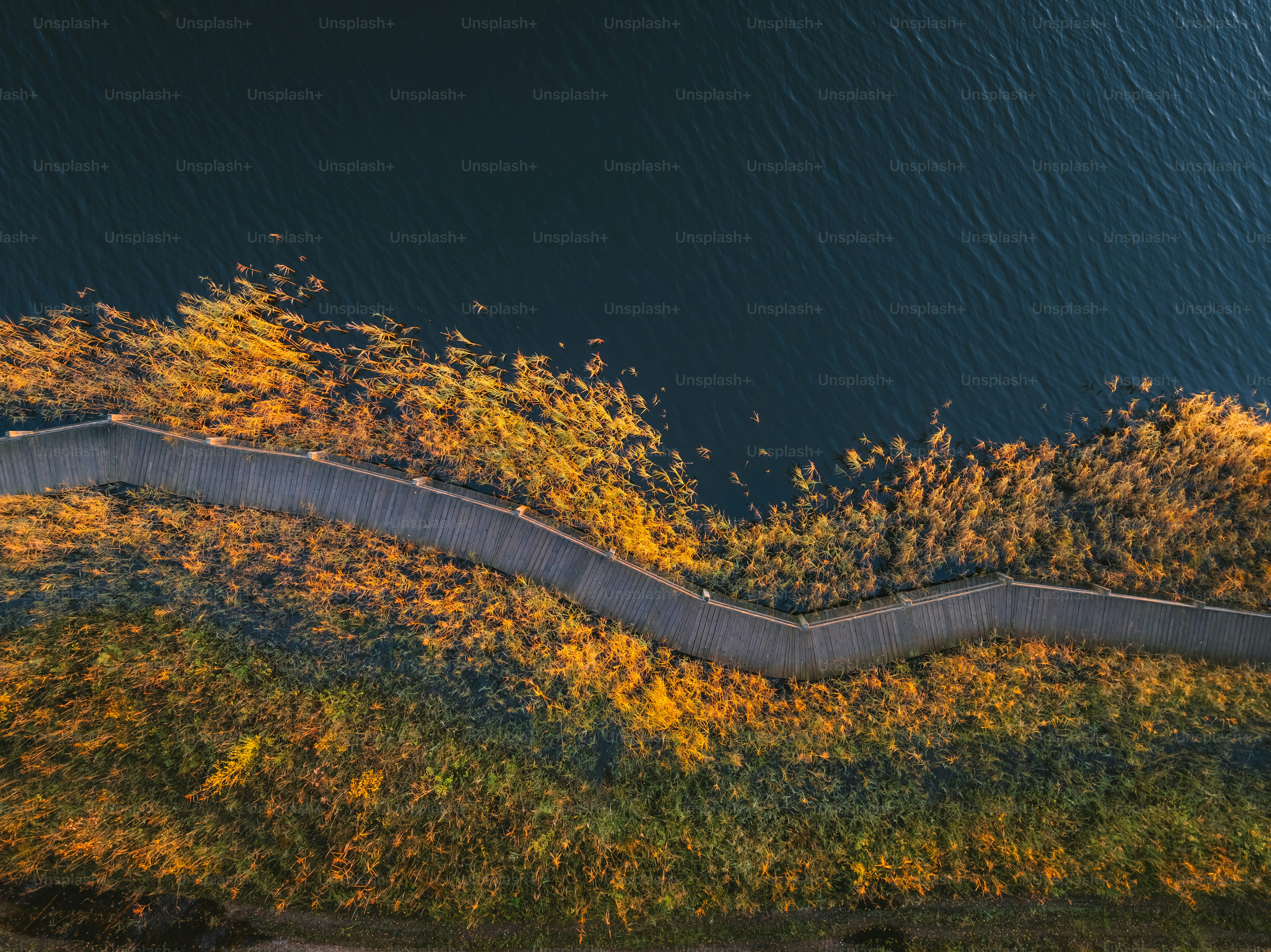 An aerial view of a winding road next to a body of water
