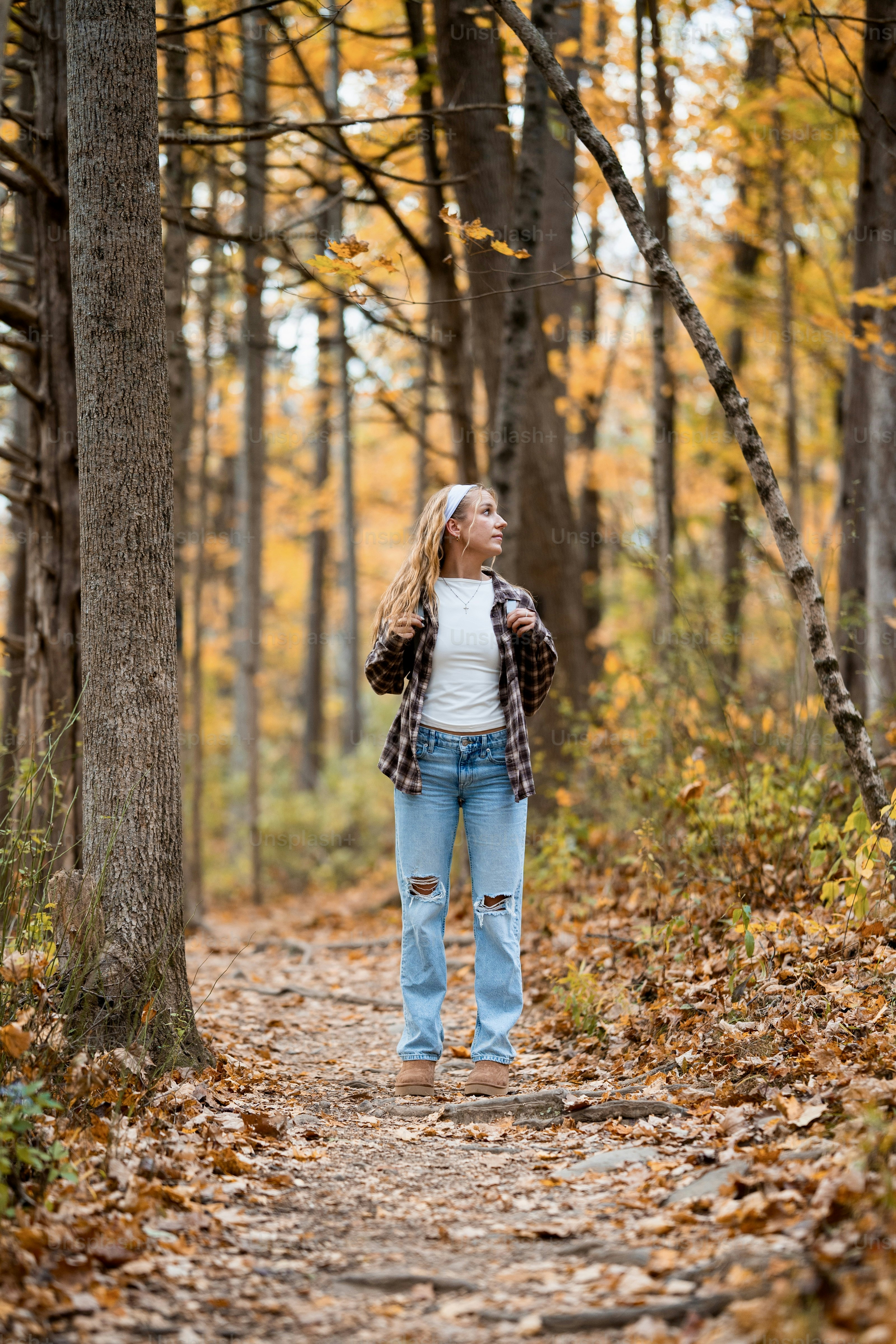 A woman standing in the middle of a forest
