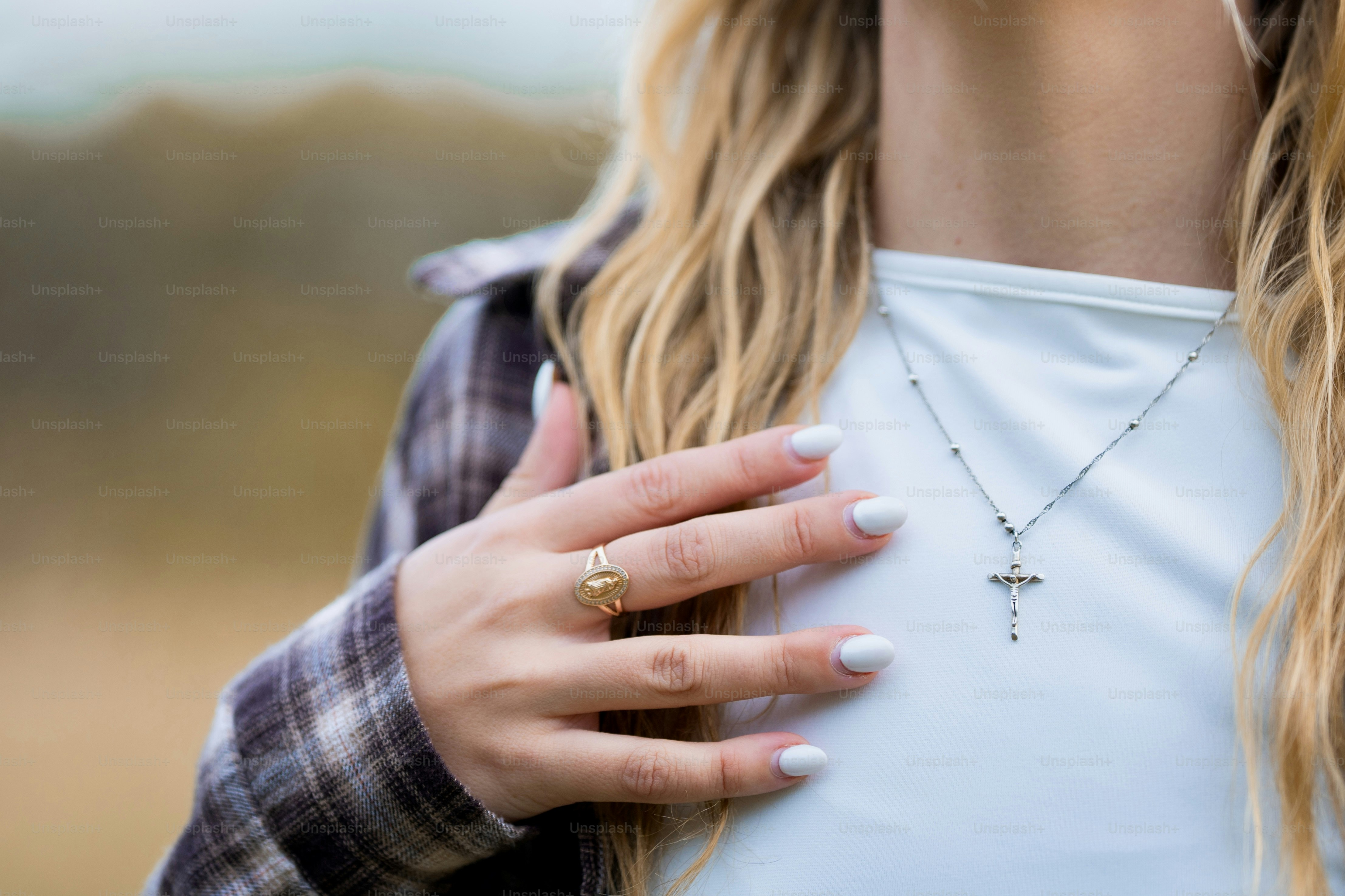 A close up of a person wearing a cross necklace