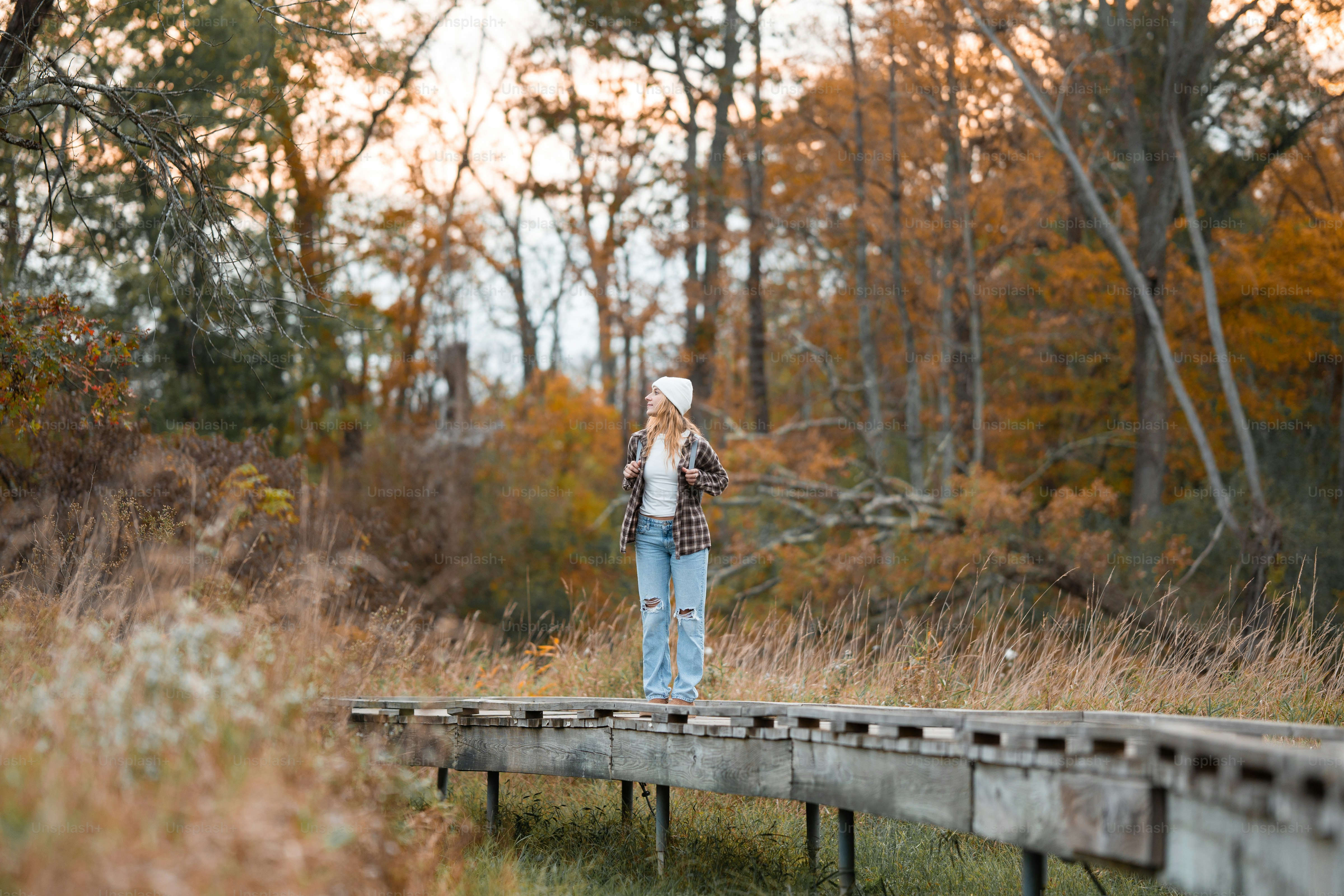 A man standing on a wooden bridge in the woods
