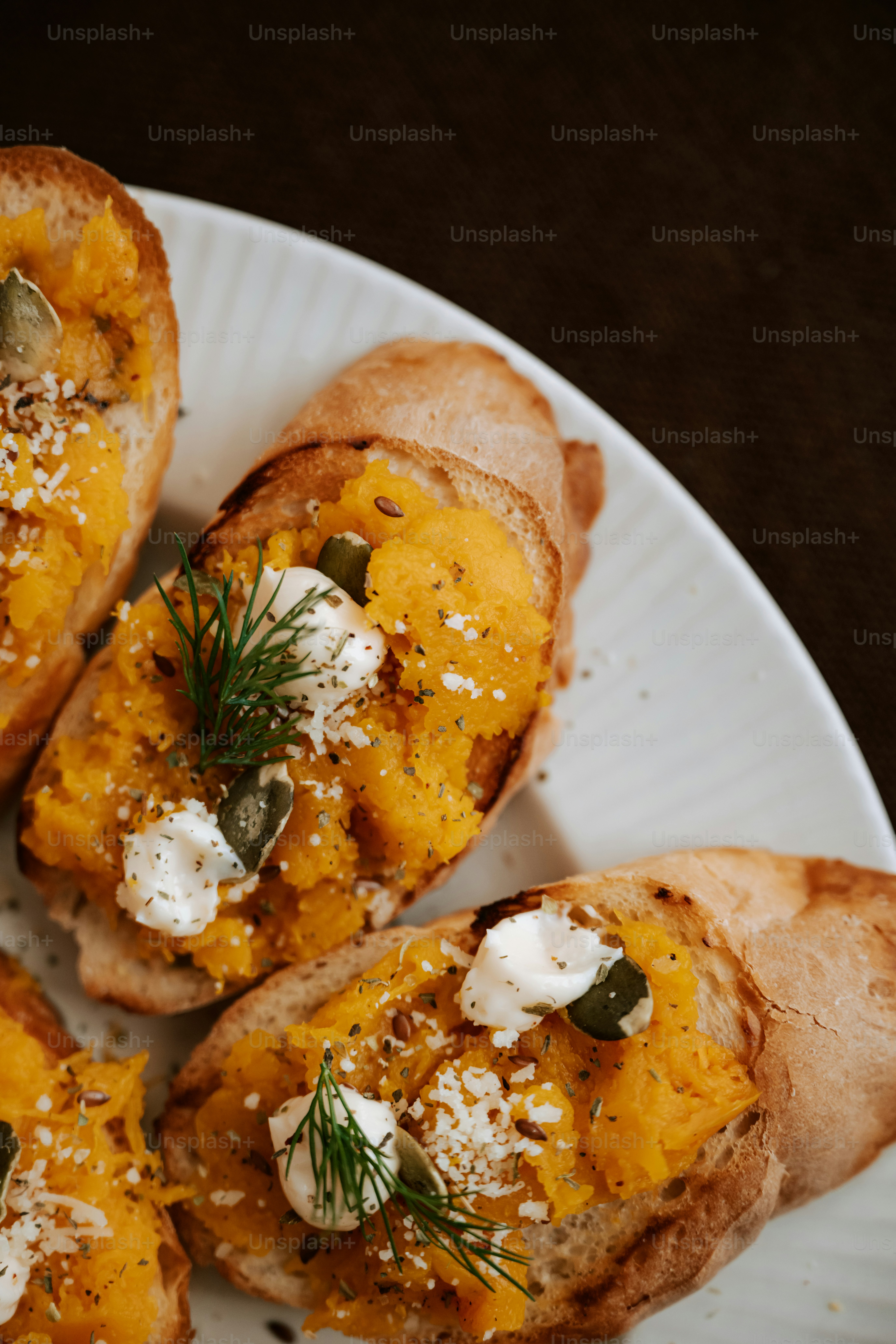 Ein weißer Teller mit Brot, das mit Käse überzogen ist