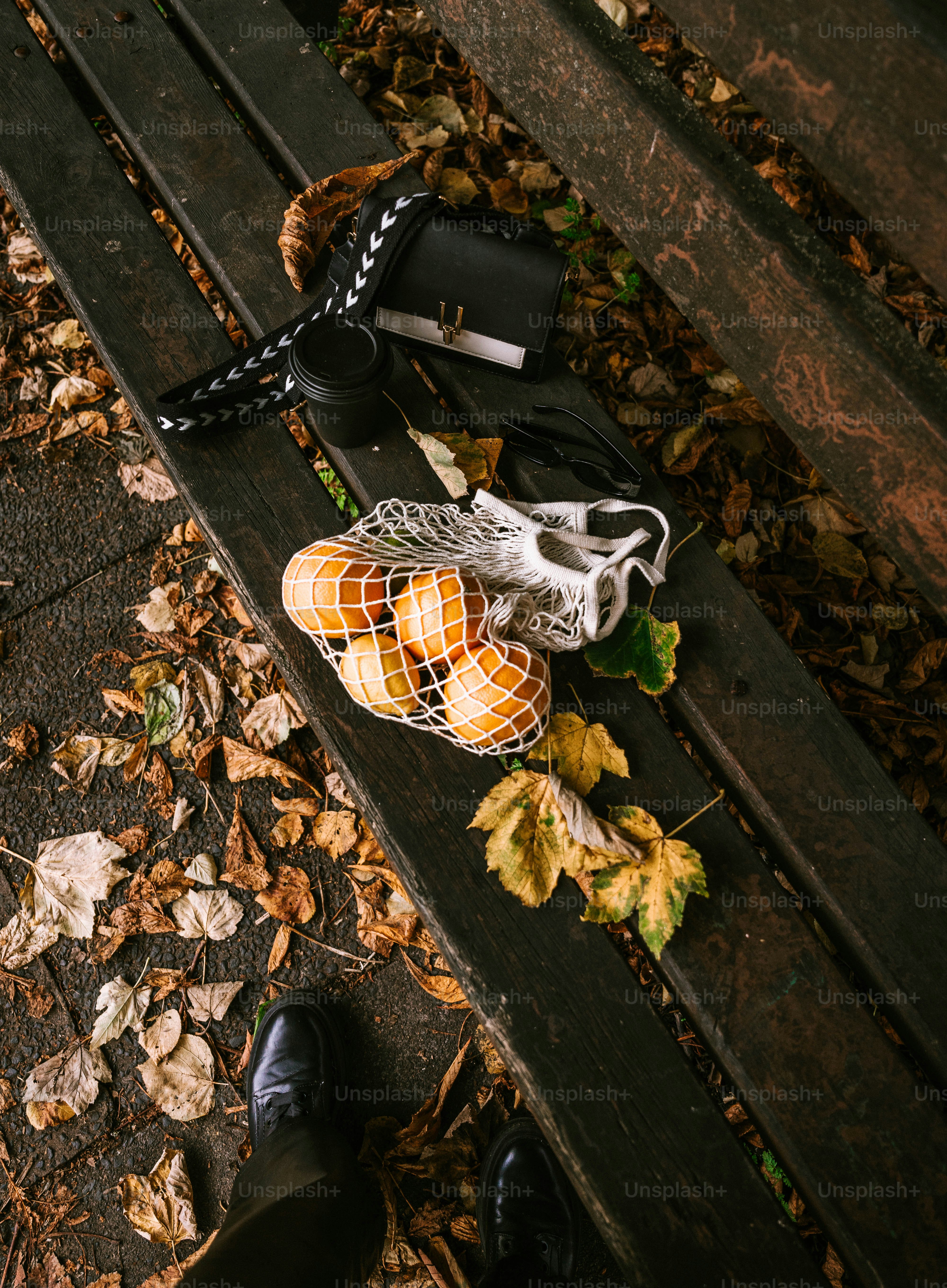 Une personne debout à côté d’un sac sur un banc de parc