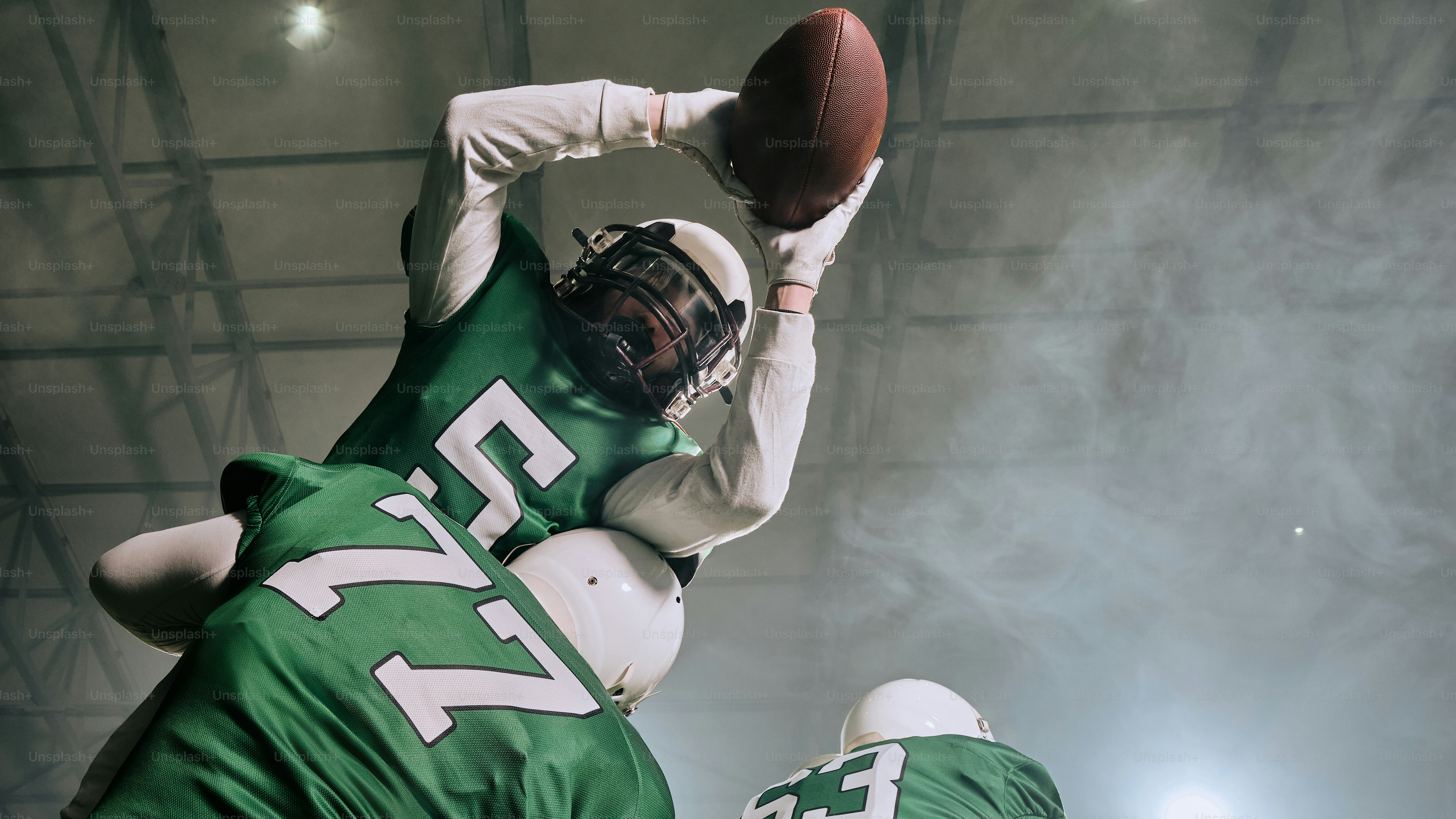 A football player jumping up into the air to catch a ball