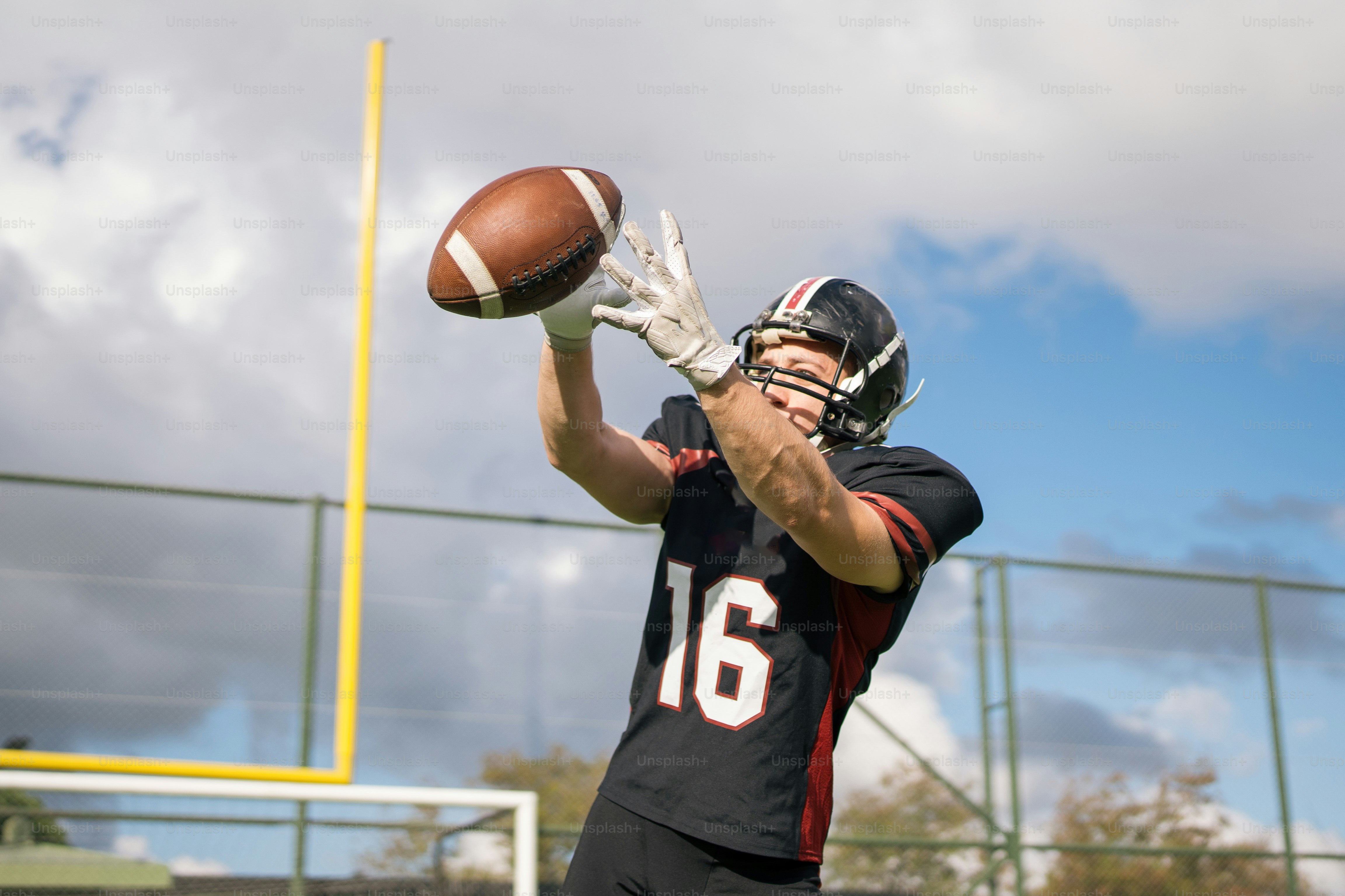 A man holding a football on top of a field