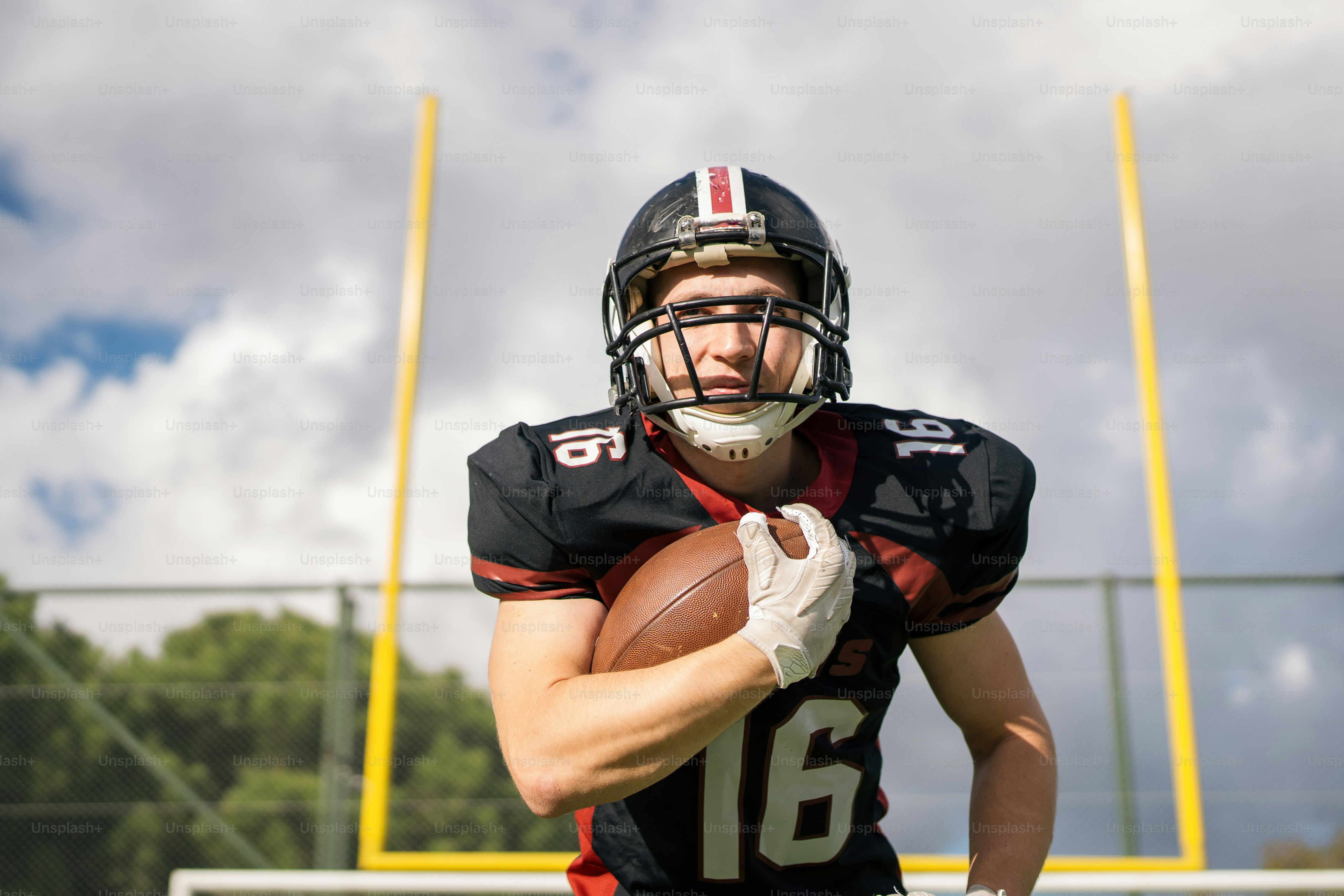 A football player holding a football on a field
