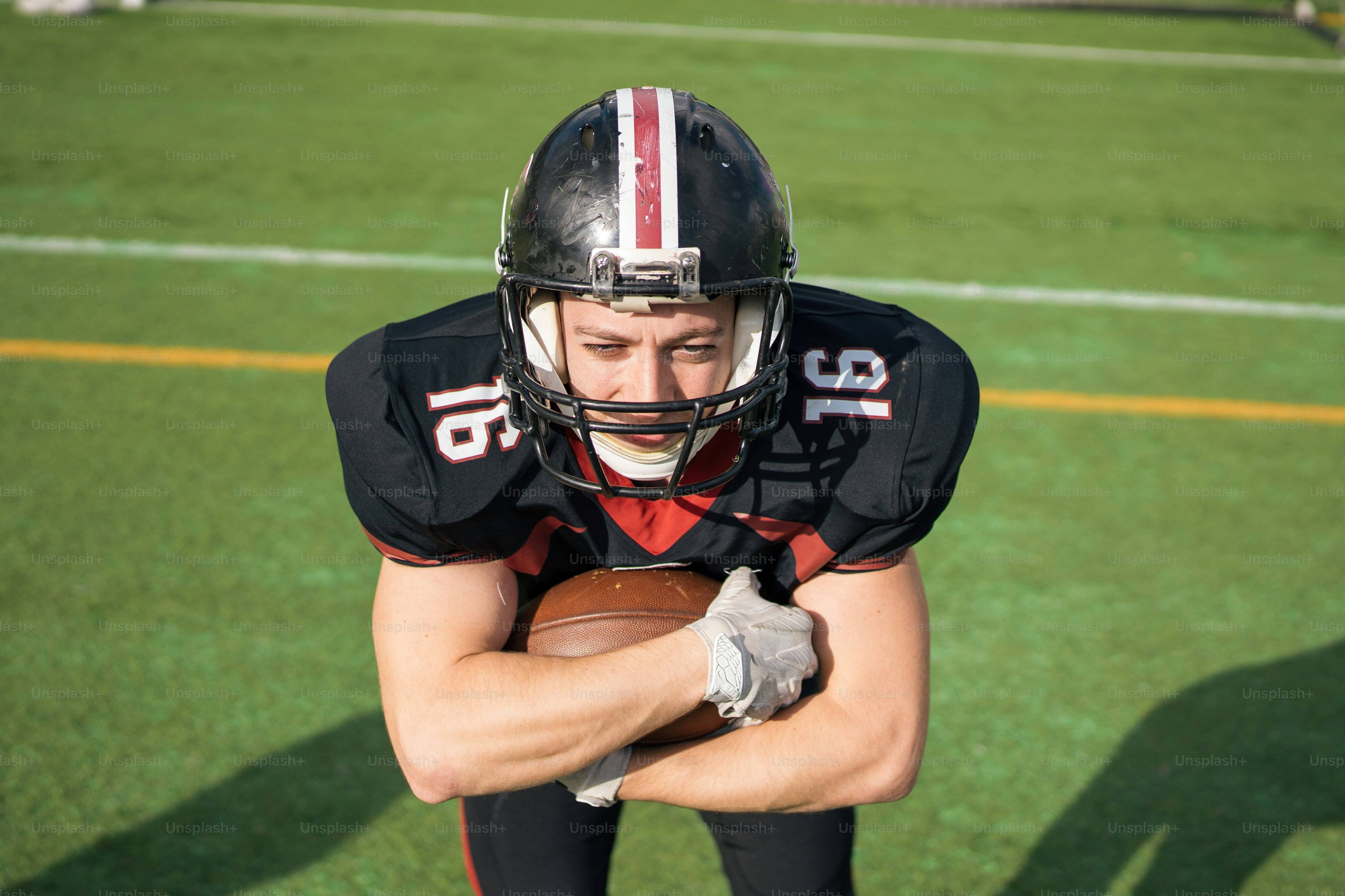 A football player holding a football on a field