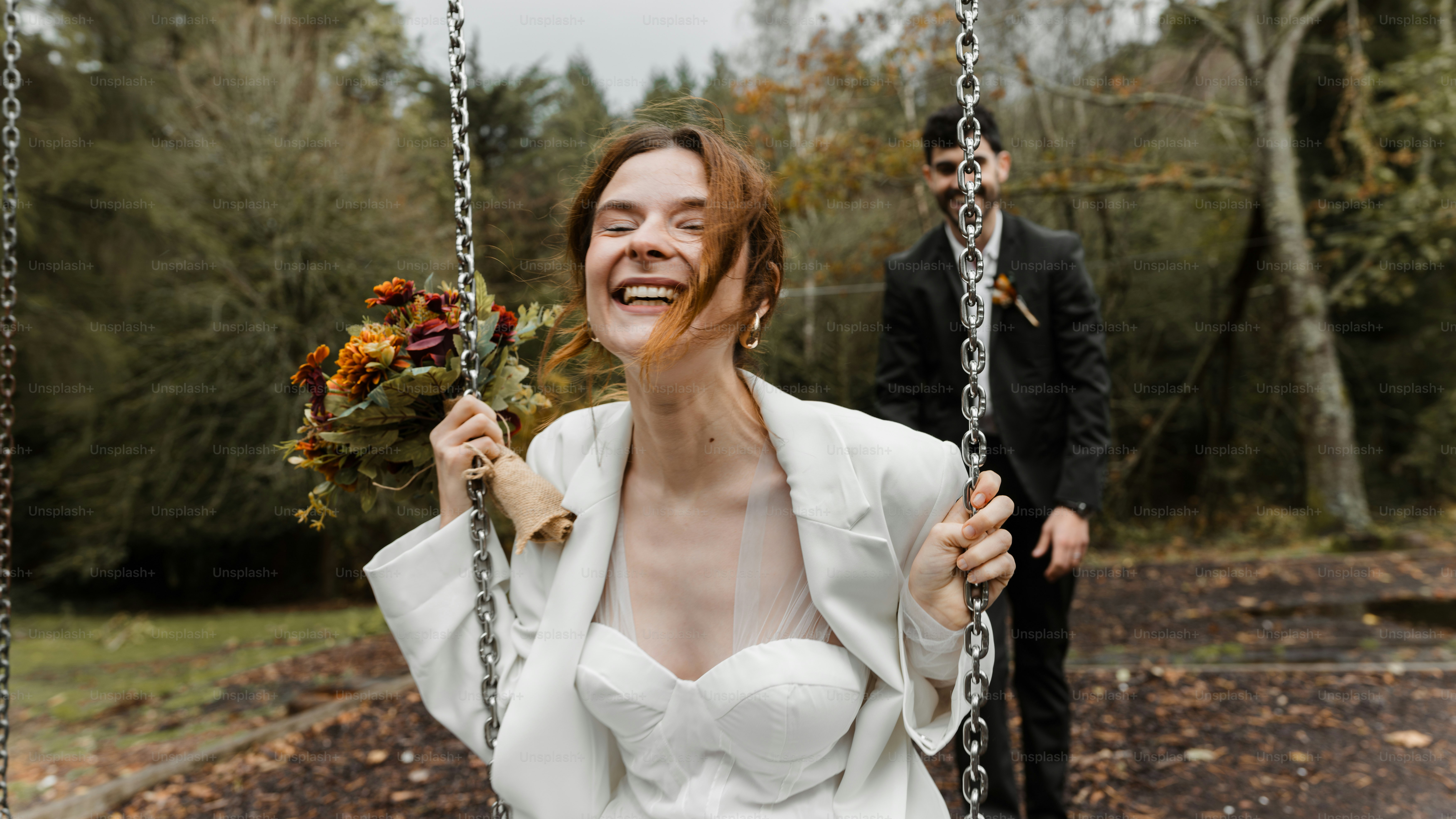 A woman sitting on a swing with a man standing behind her