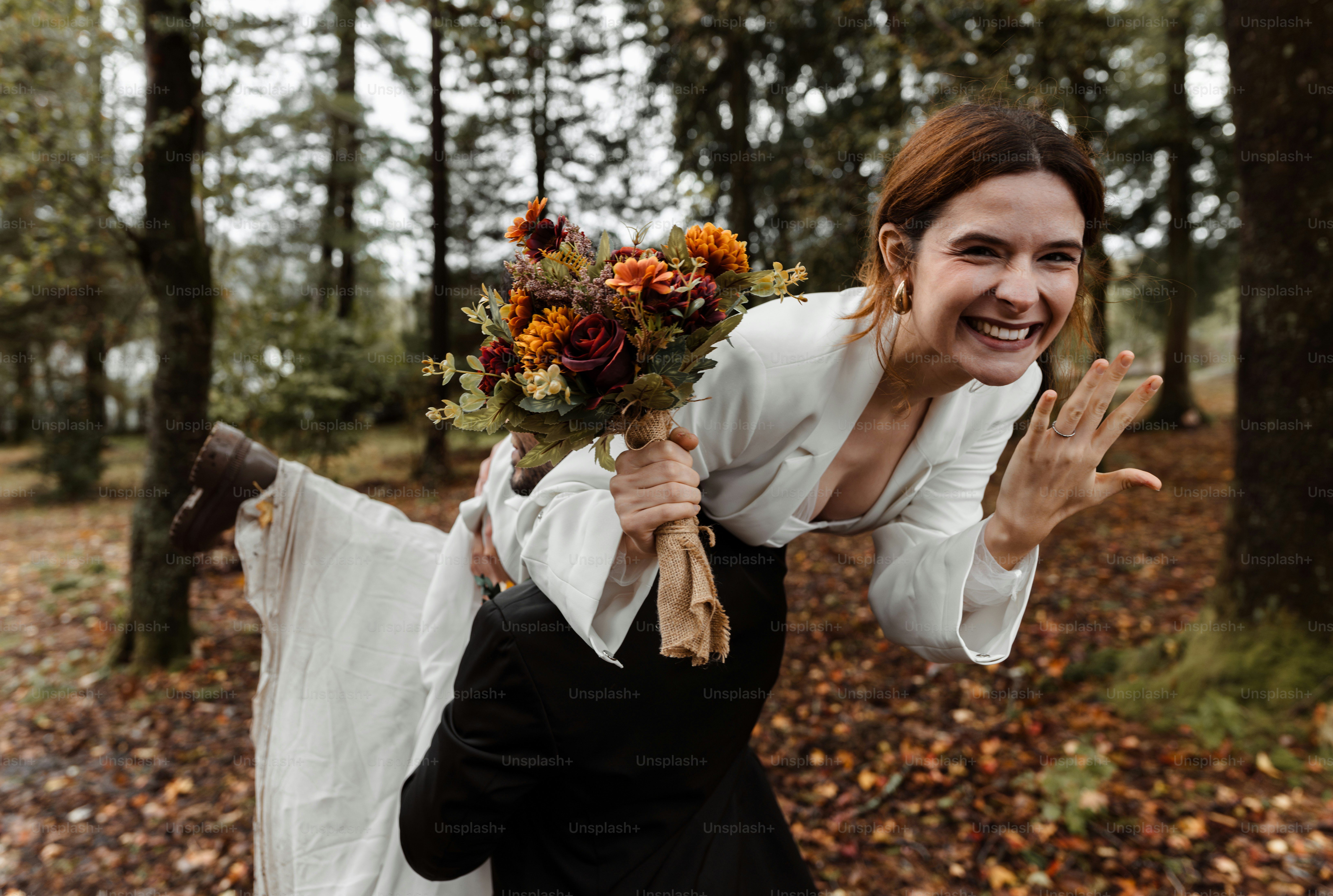 A woman holding a bouquet of flowers in a forest