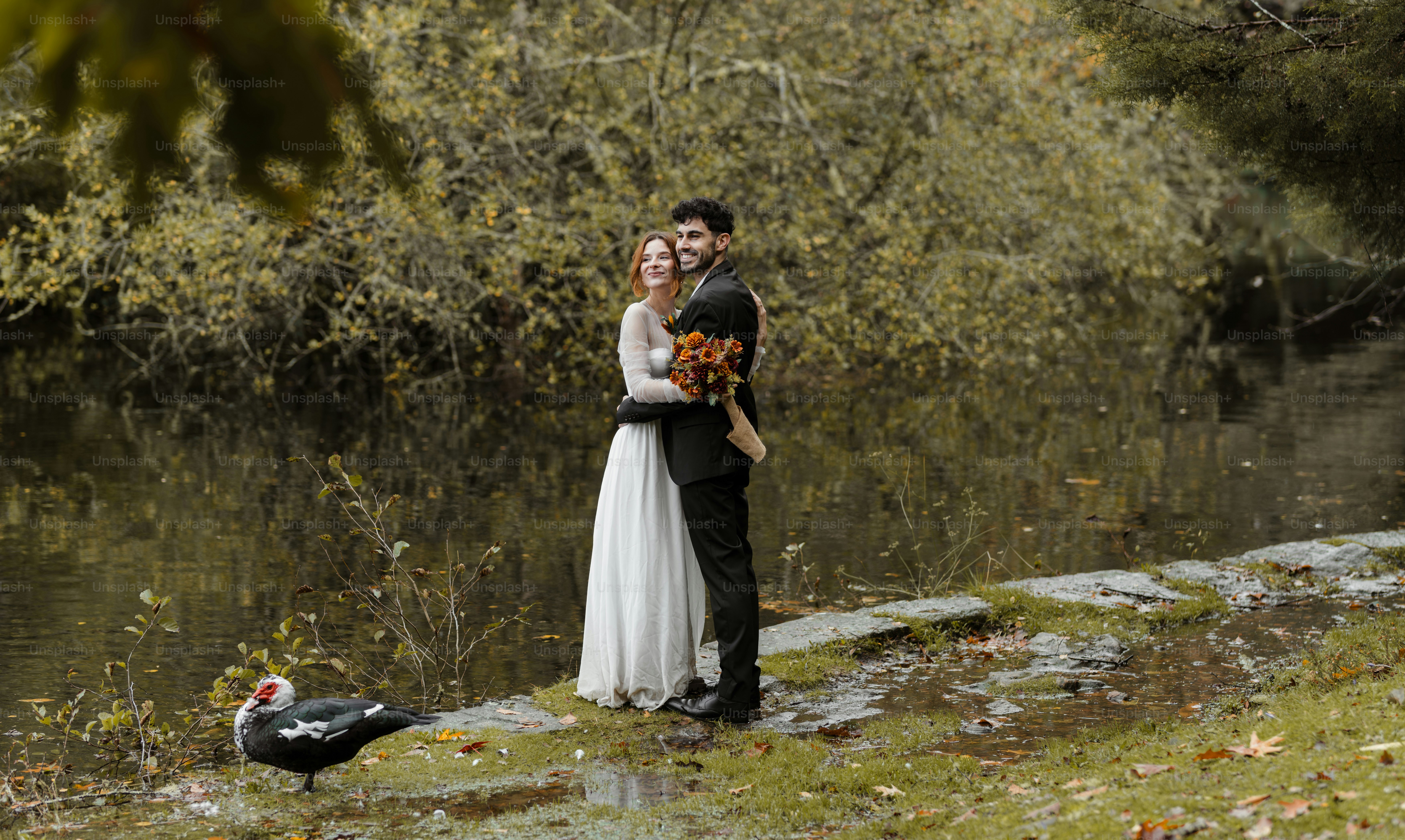 A man and a woman standing next to a body of water