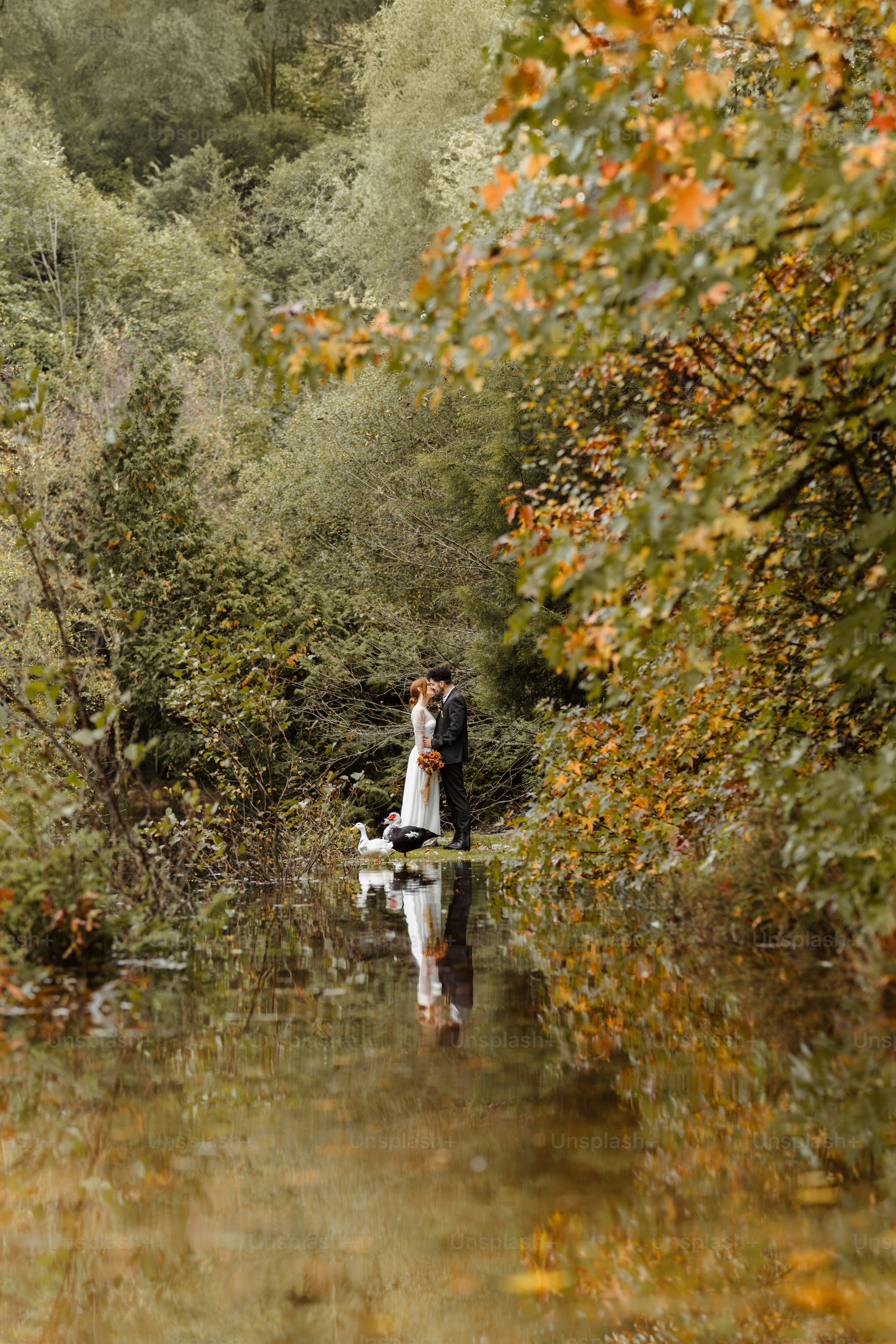 A bride and groom are standing in the water