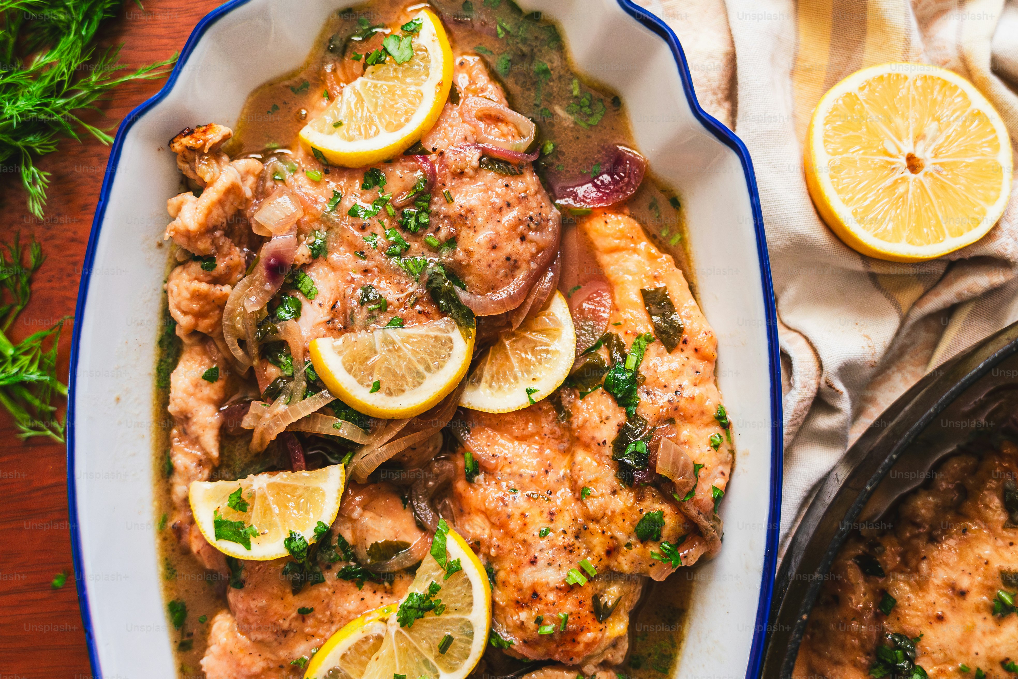 A white plate topped with chicken and lemons