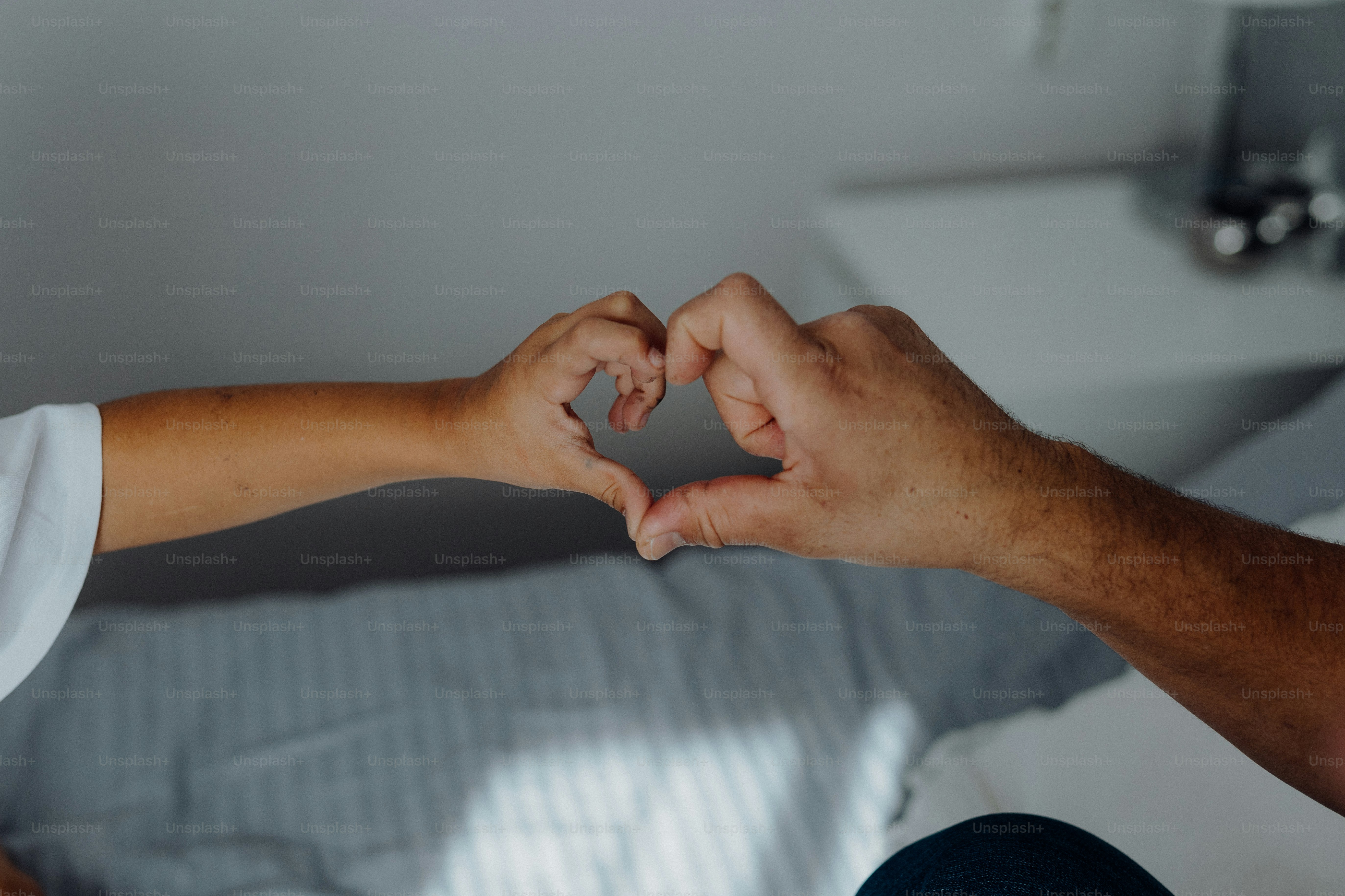 A man and a woman making a heart shape with their hands