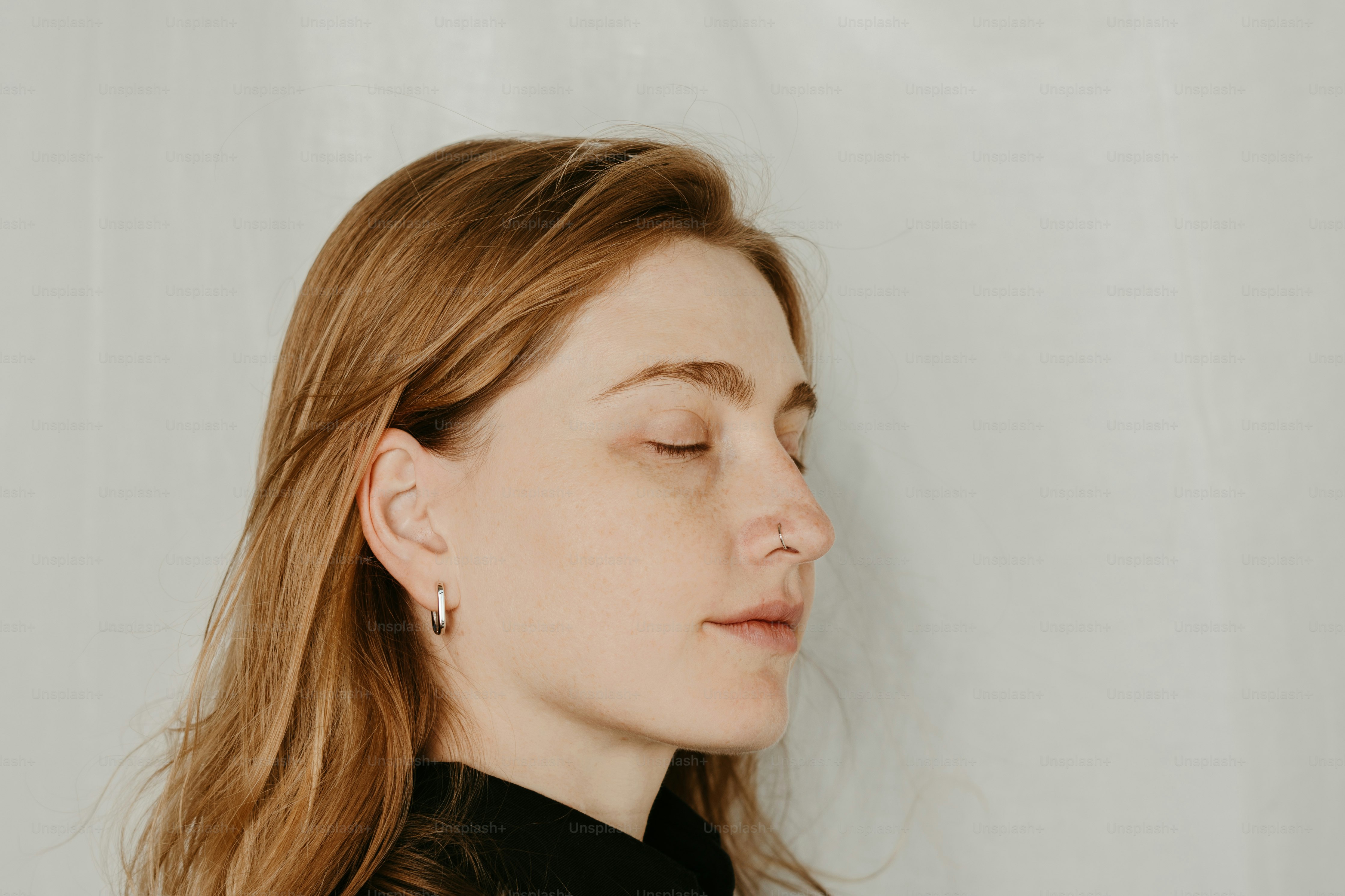 A woman with her eyes closed wearing a black shirt