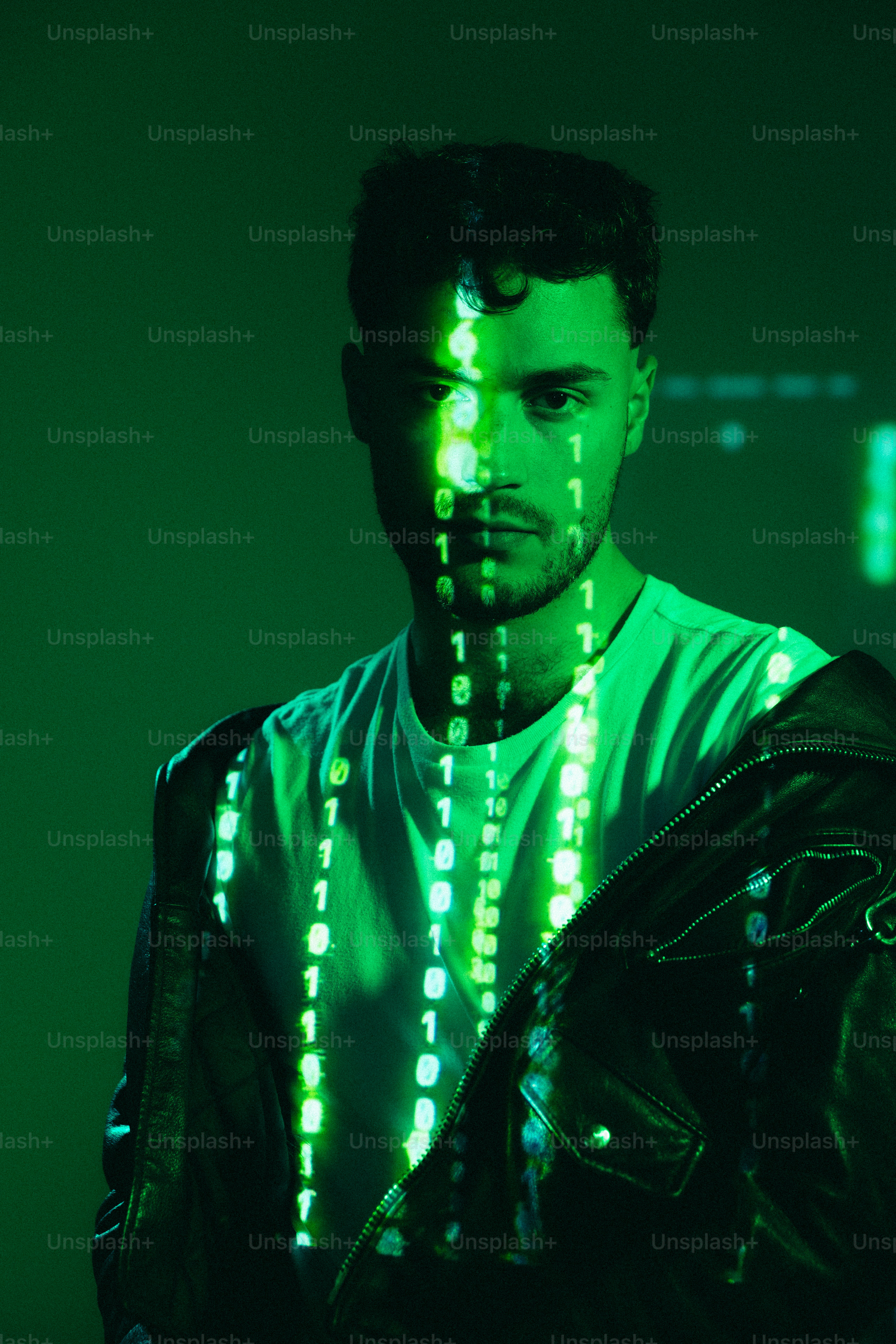 A man standing in front of a green background