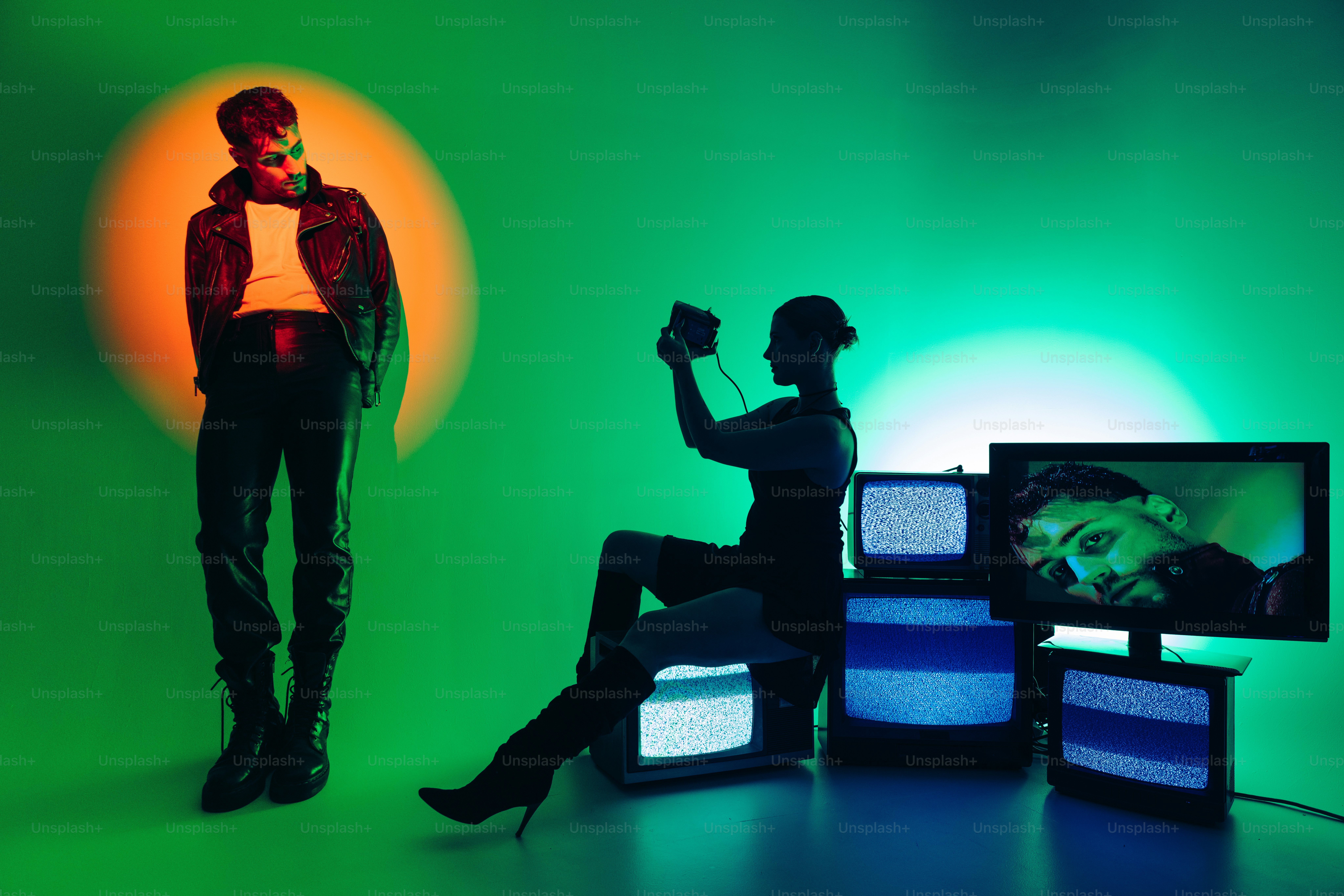 A man standing next to a woman in front of televisions