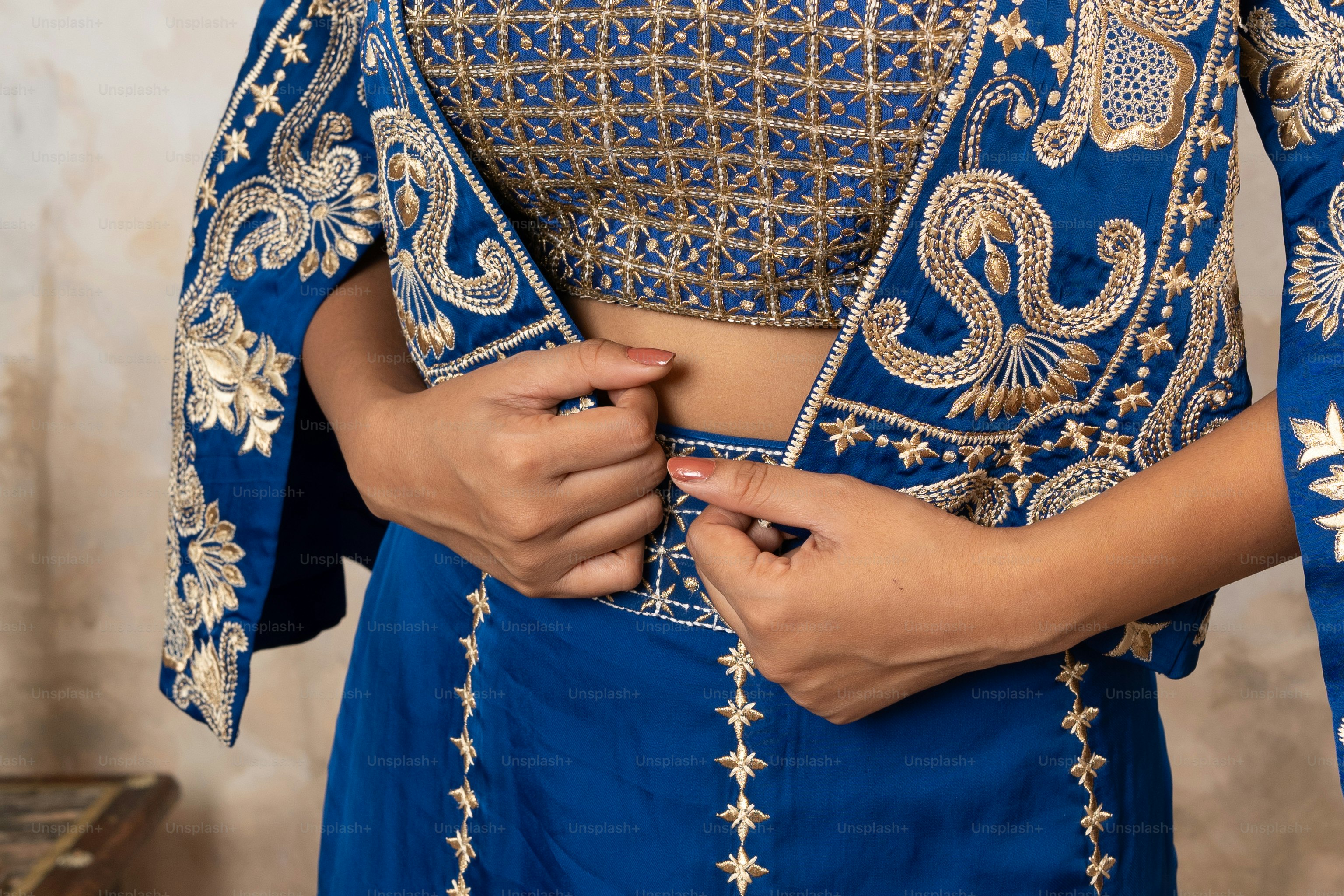 A woman wearing a blue outfit with gold details