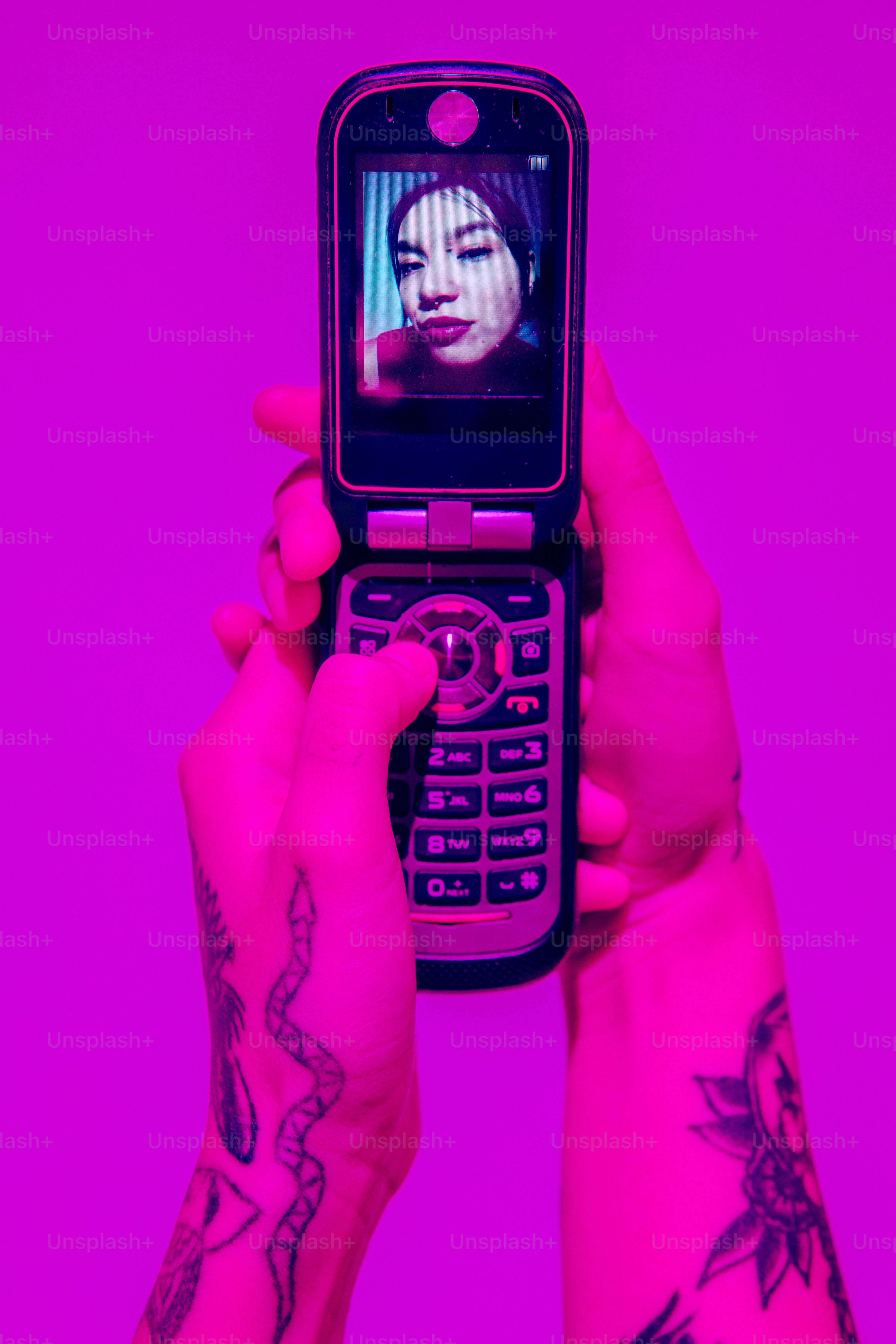 Eine Person, die ein Mobiltelefon vor ihr Gesicht hält