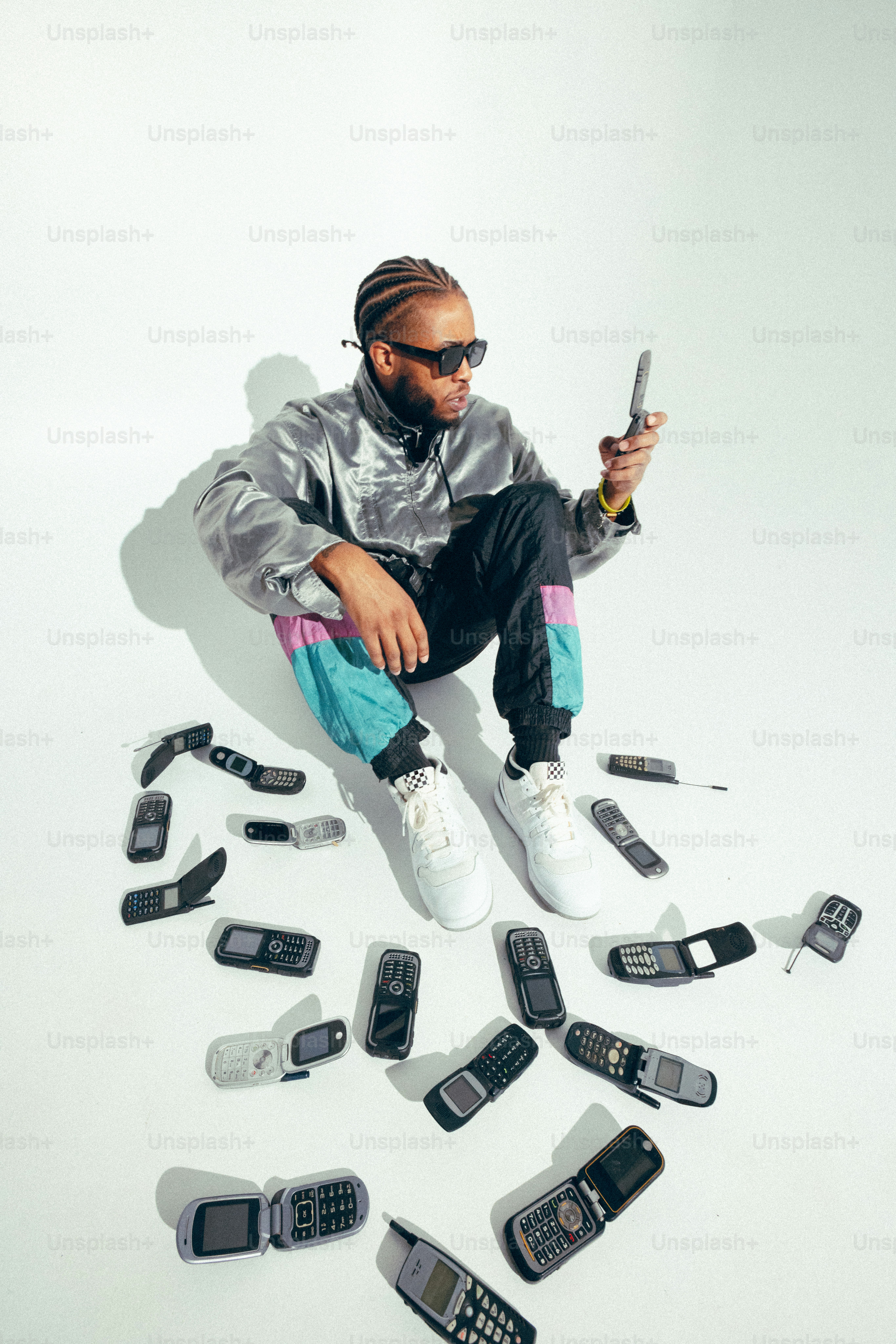 A man sitting on top of a pile of cell phones