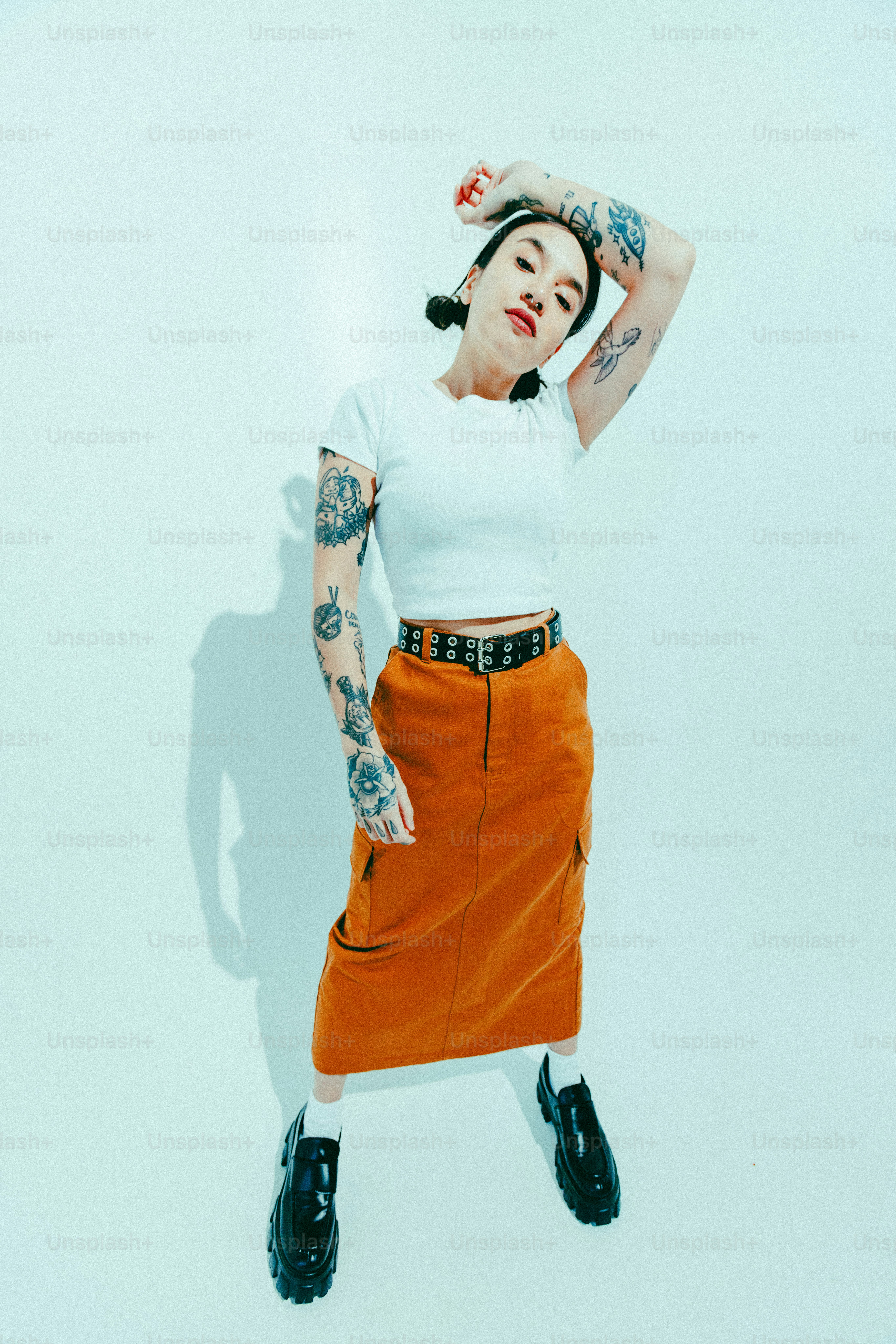 Uma mulher em uma camisa branca e saia laranja