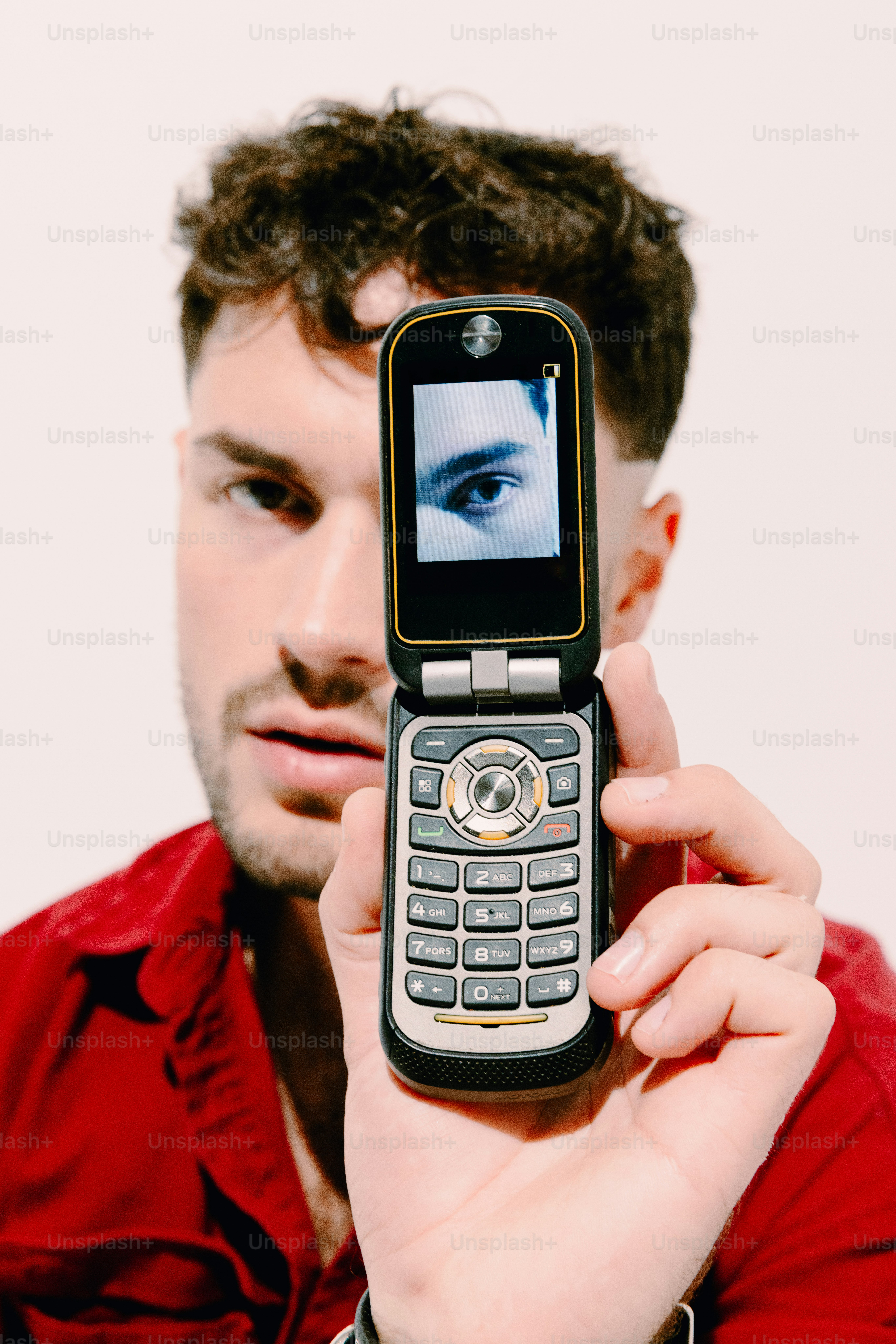 Un hombre sosteniendo un teléfono celular frente a su cara