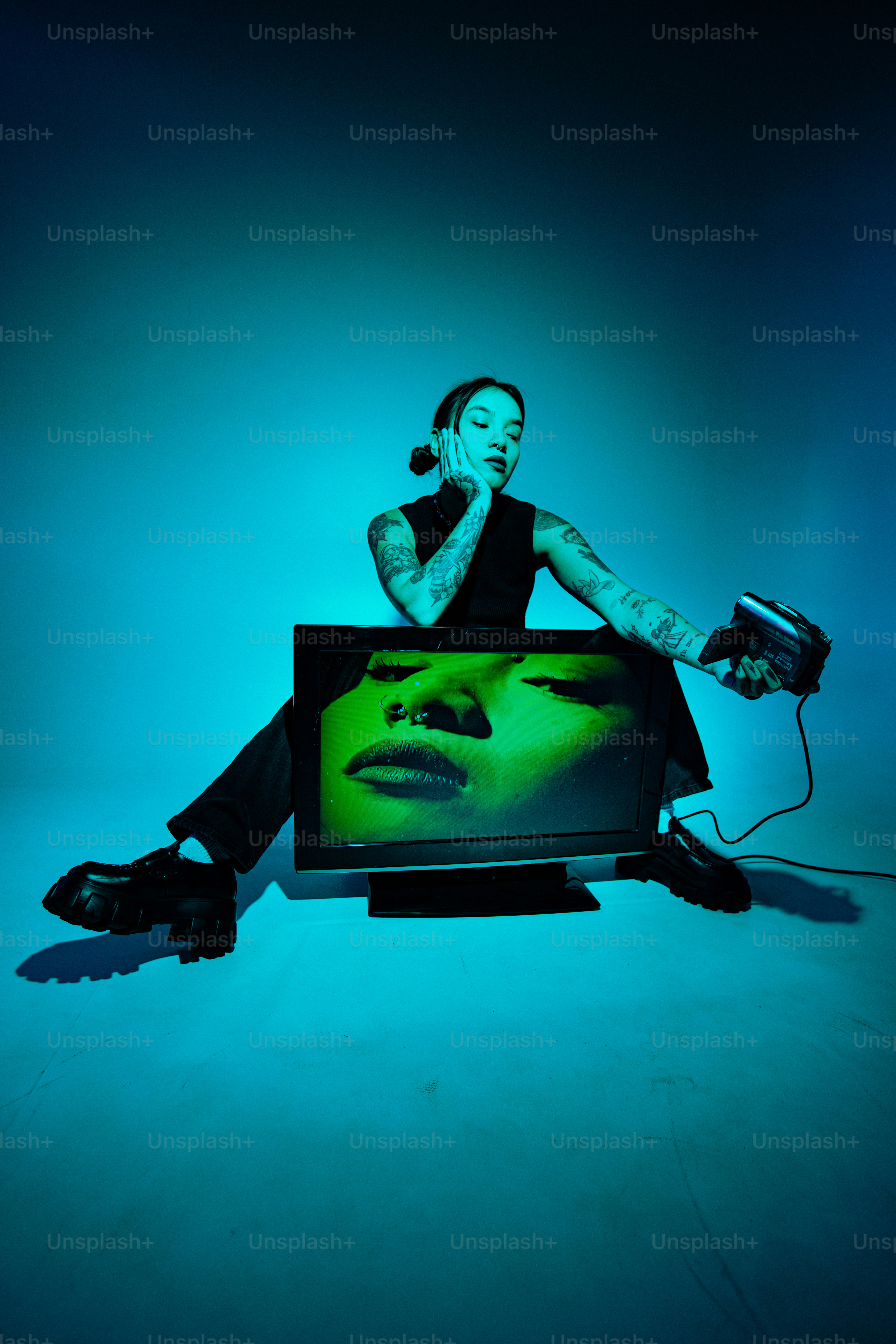 Una donna seduta davanti a un televisore che tiene una telecamera