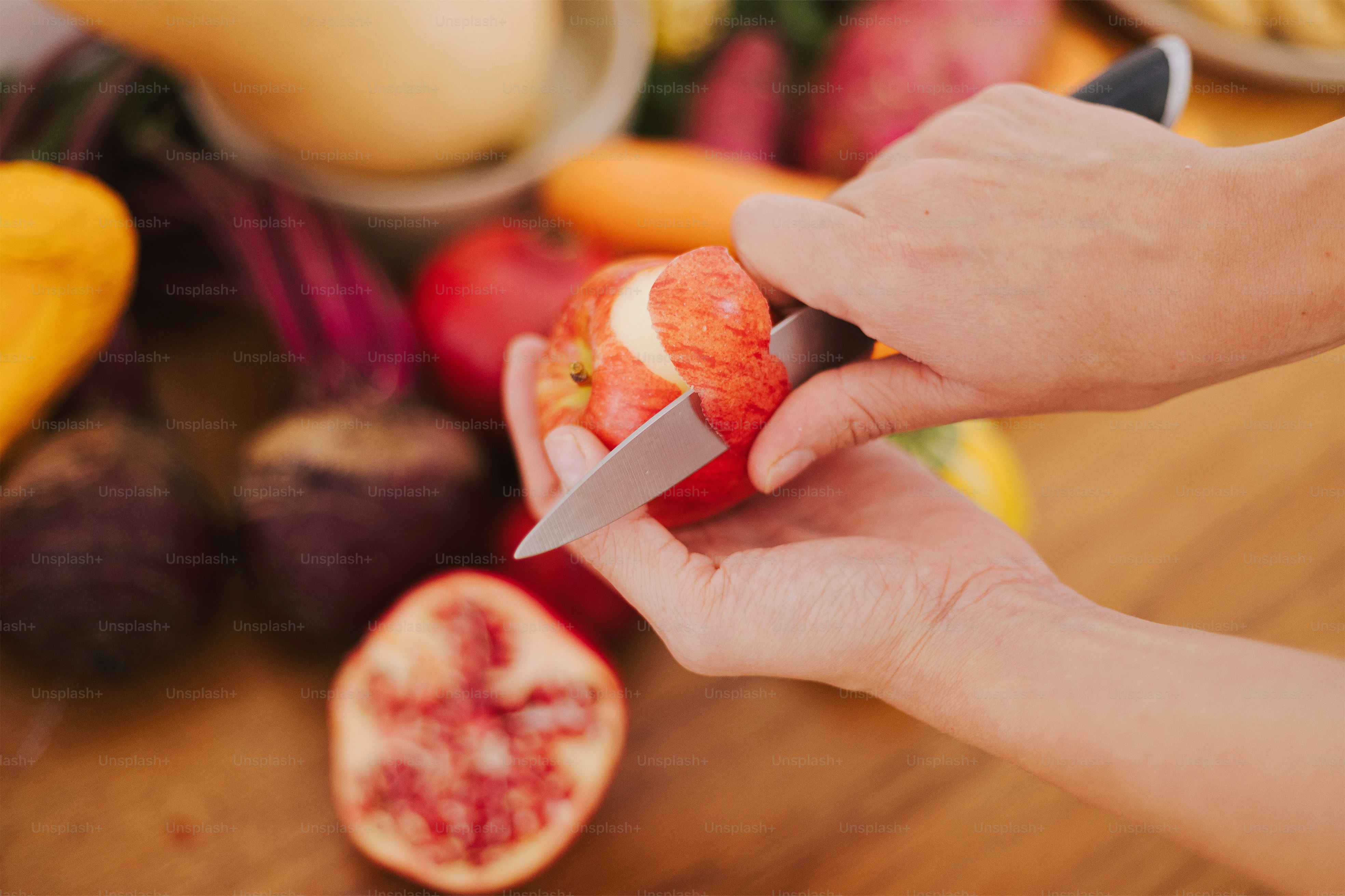 A person holding a knife and cutting a piece of fruit